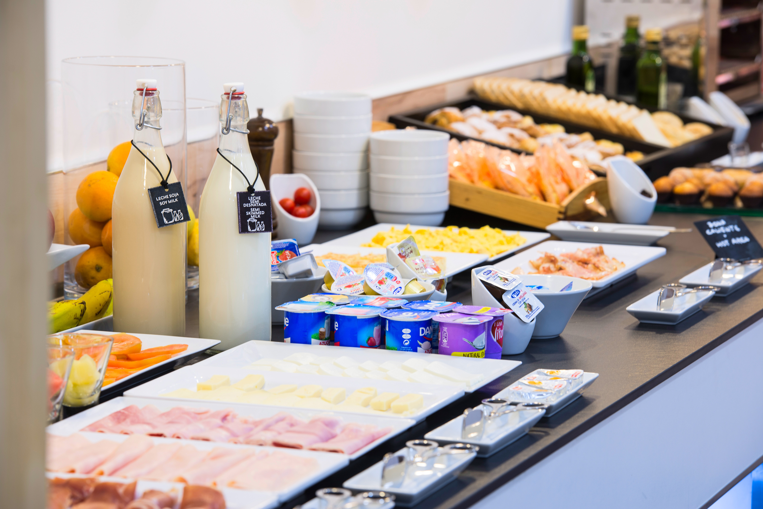 Hotel breakfast buffet with soy and skimmed milk, yogurts, cold cuts, cheese, eggs.