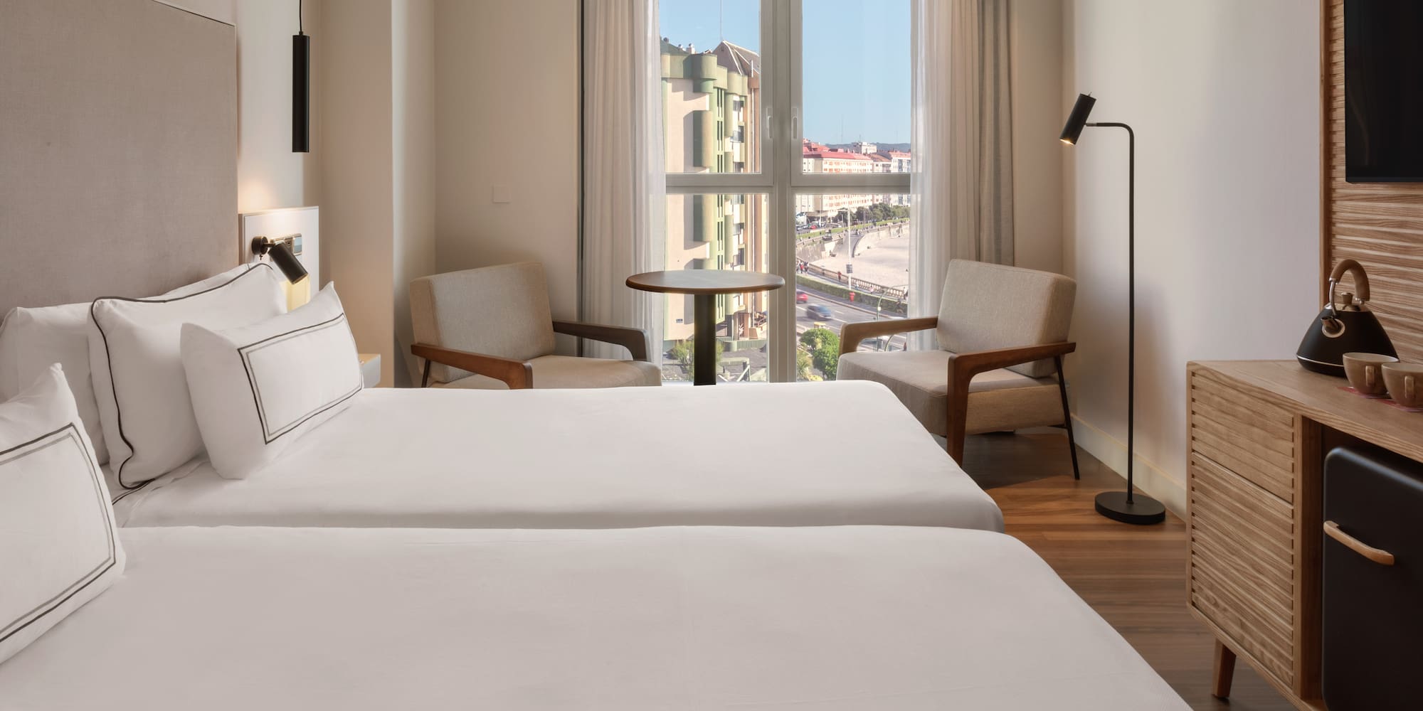 a room with two beds and a table and chairs