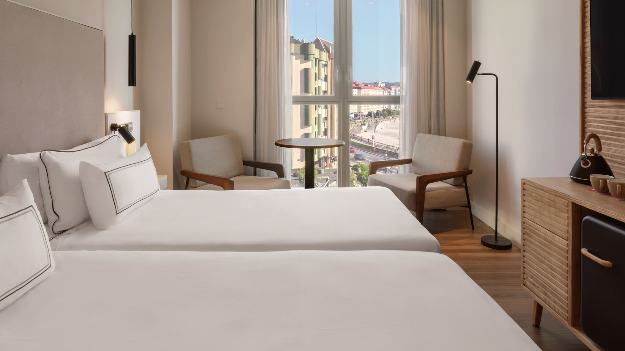 a room with two beds and a table and chairs