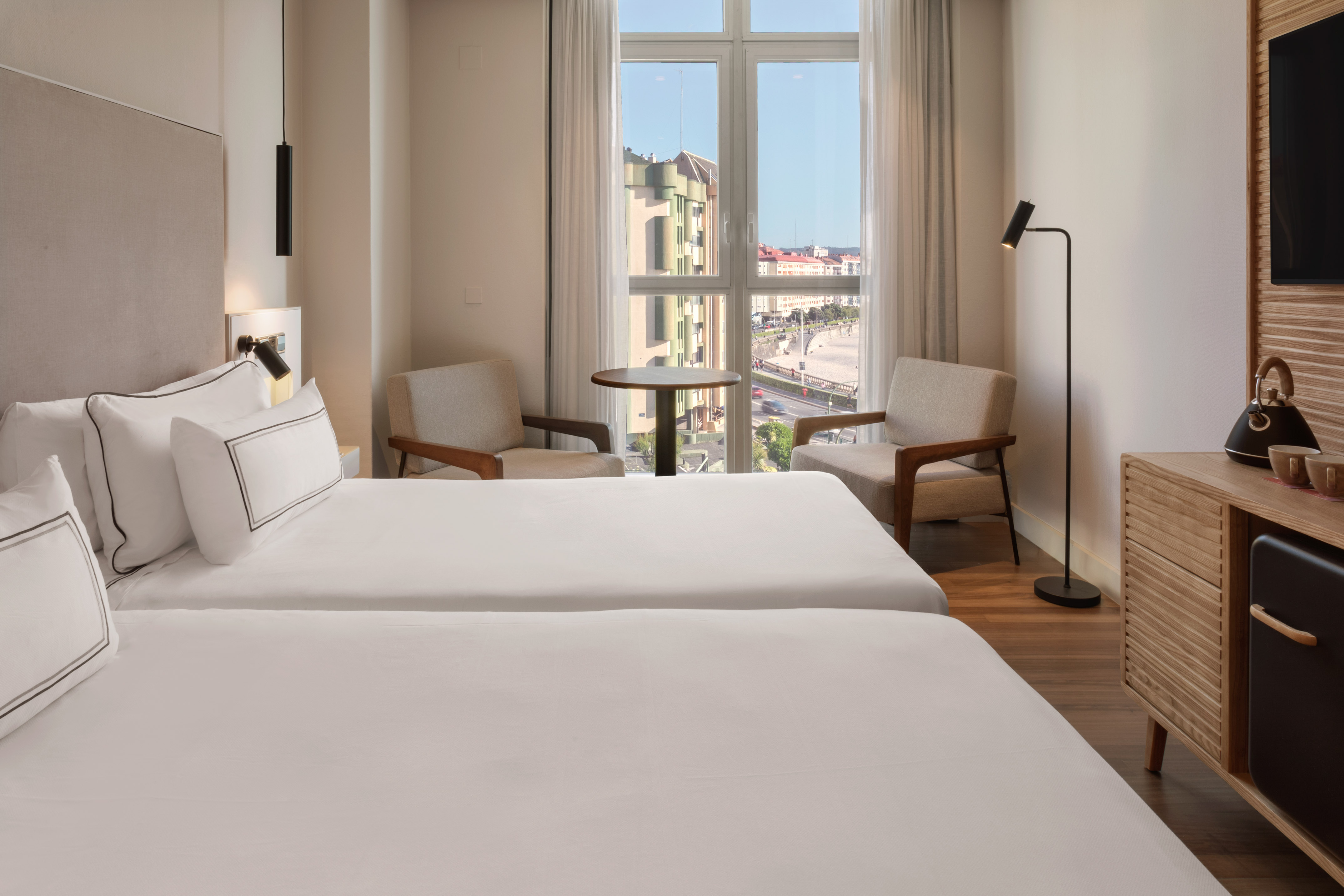 a room with two beds and a table and chairs