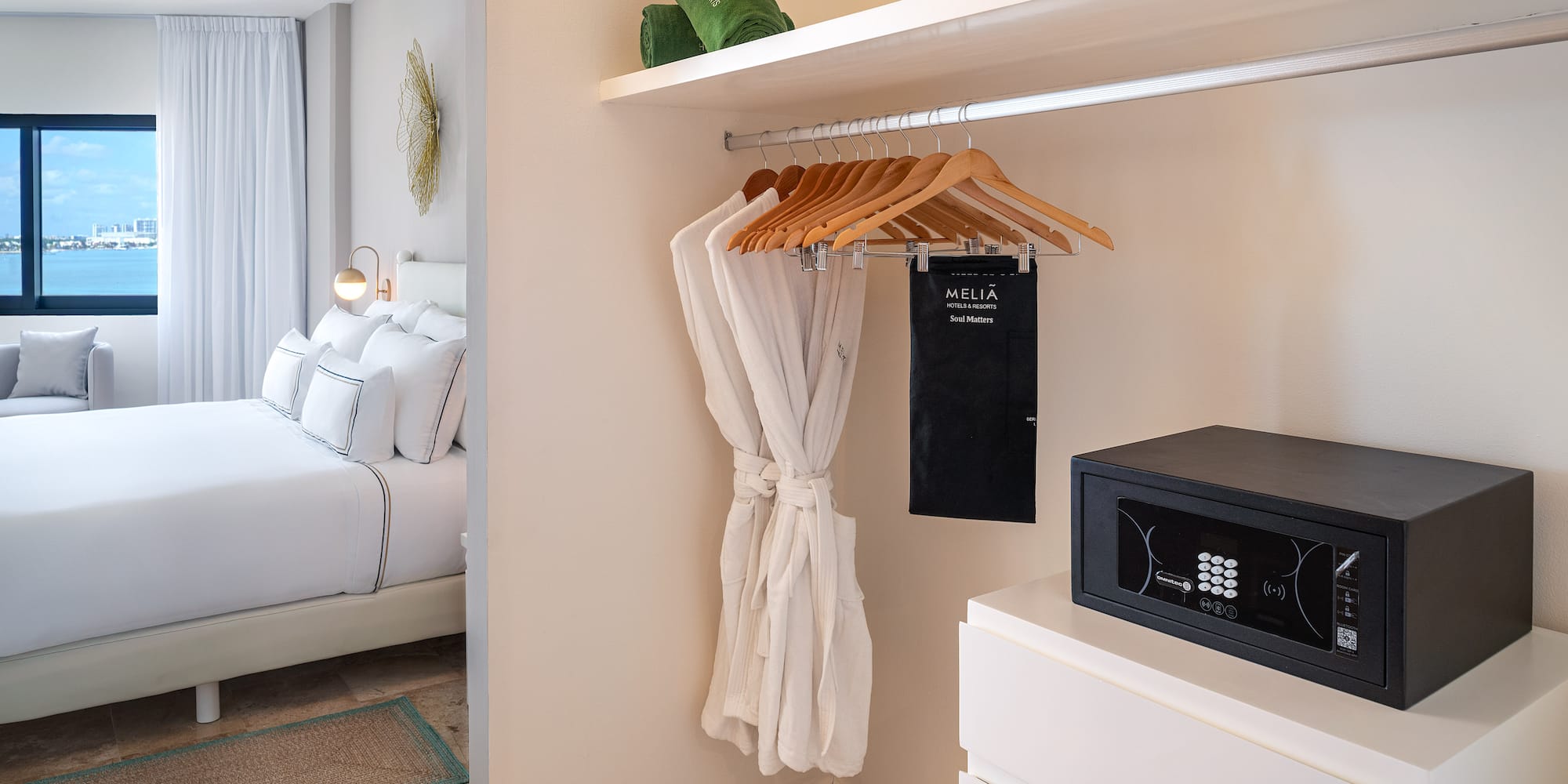 a room with a white robe and a black microwave