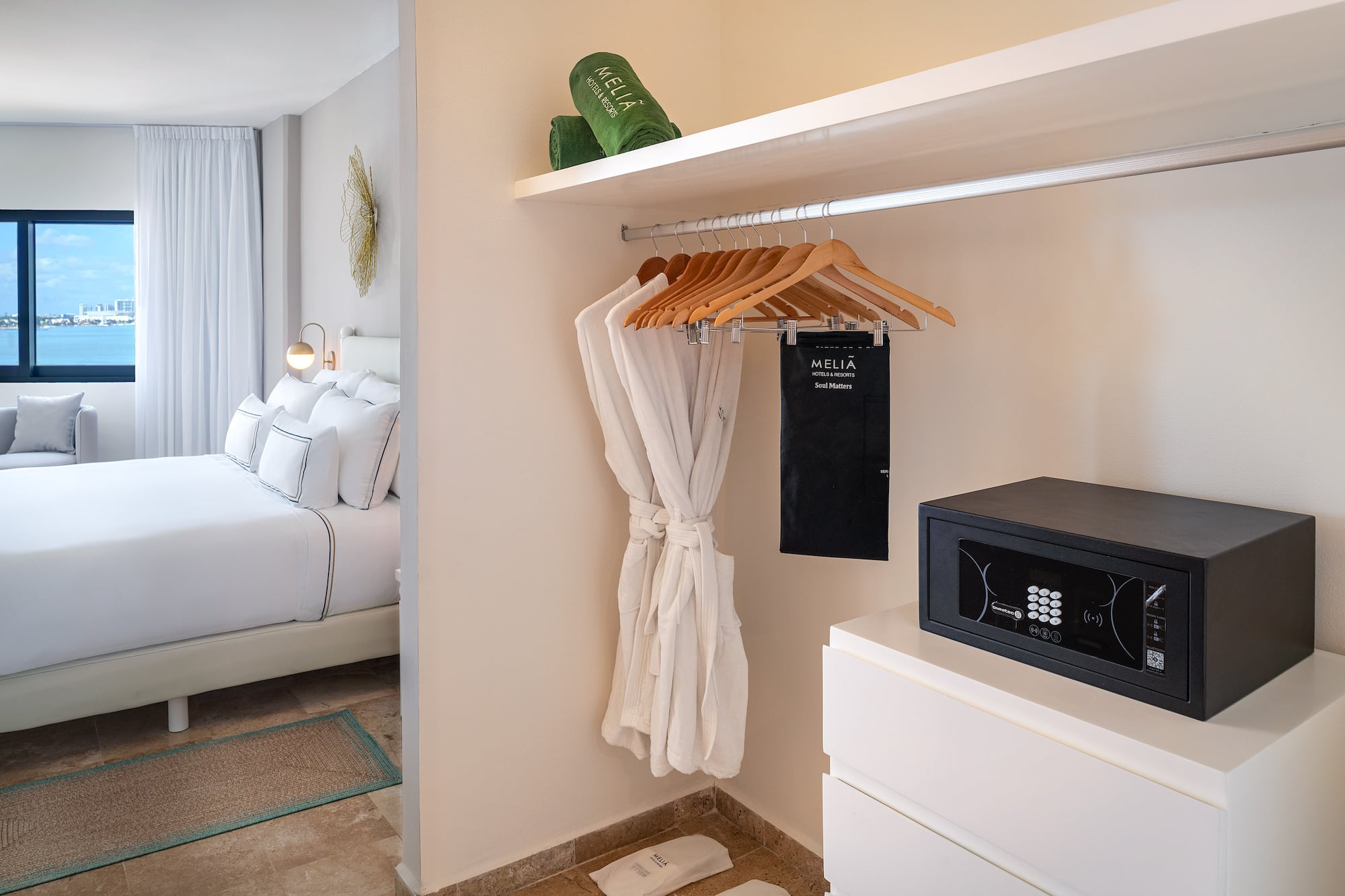 a room with a white robe and a black microwave