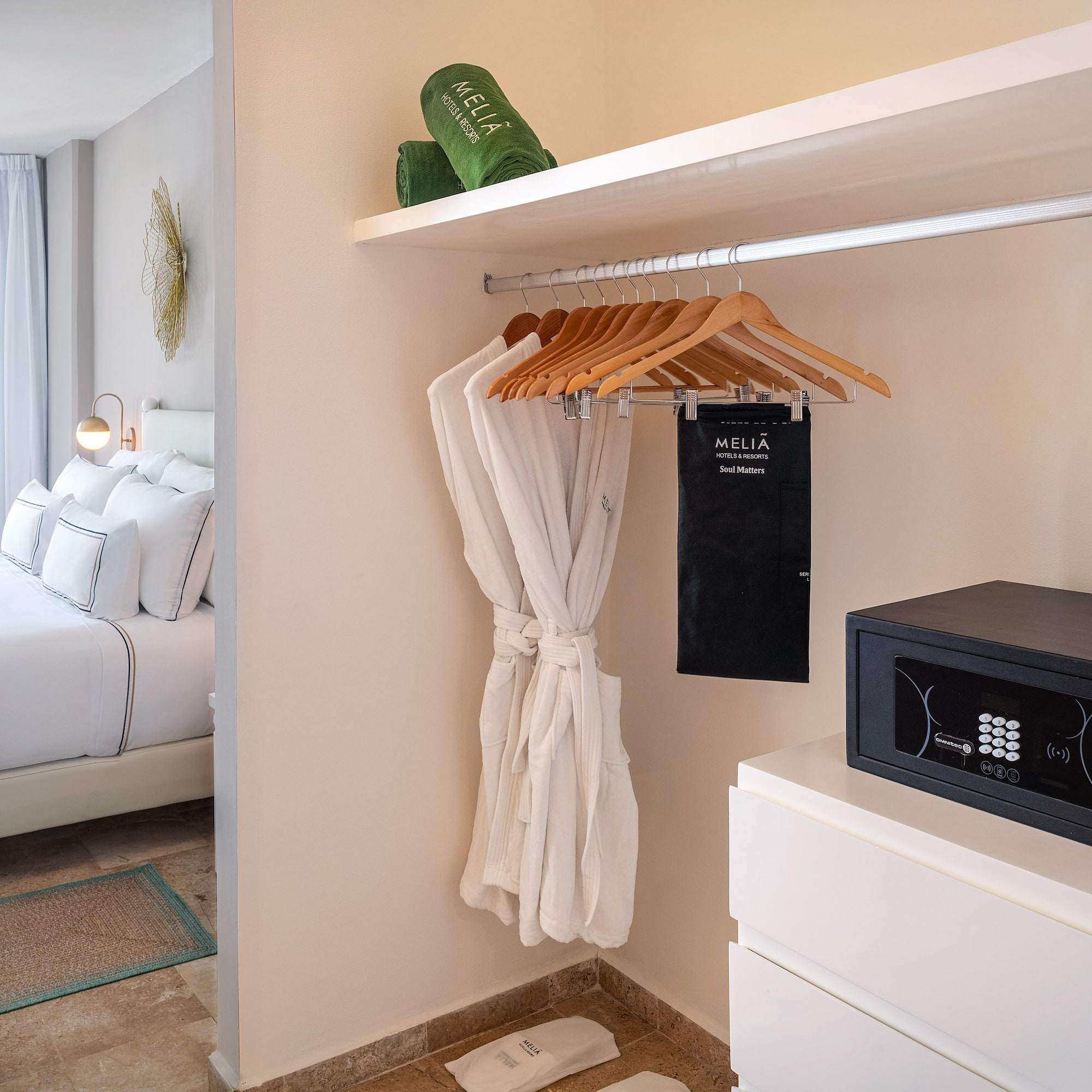 a room with a white robe and a black microwave