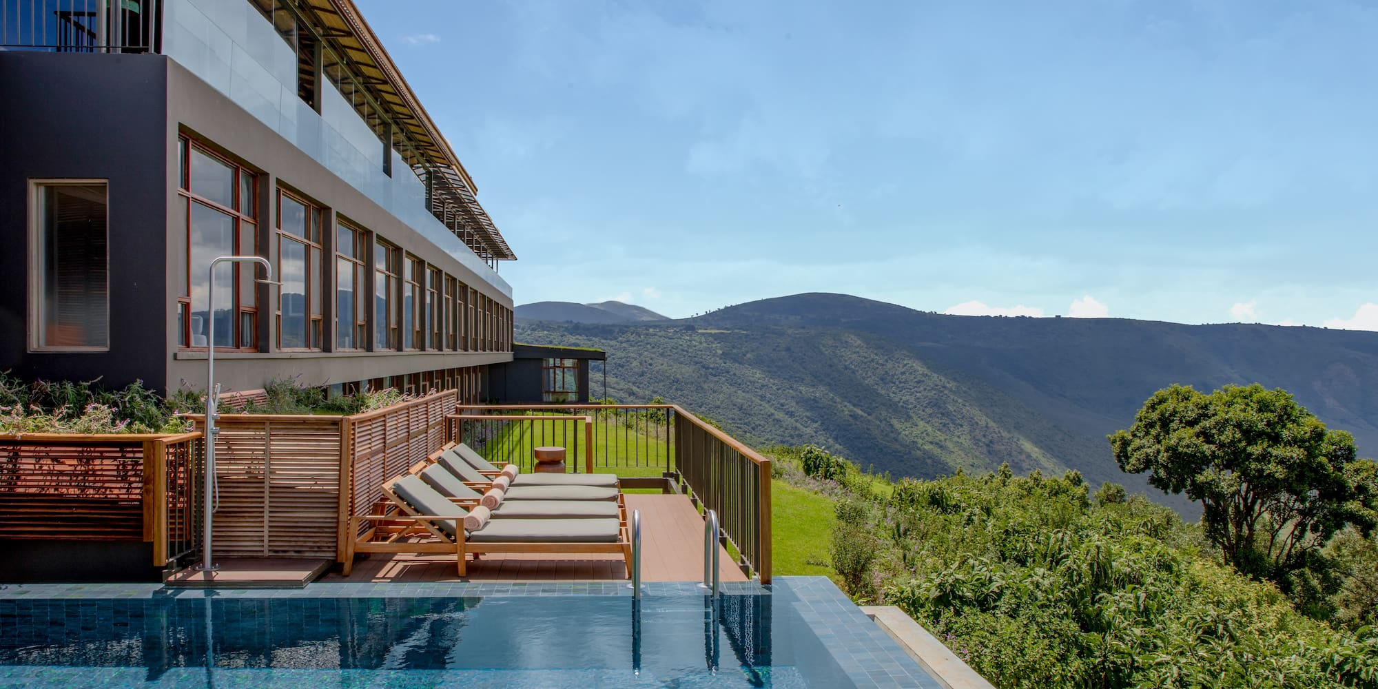 a pool with chairs and a building in the background