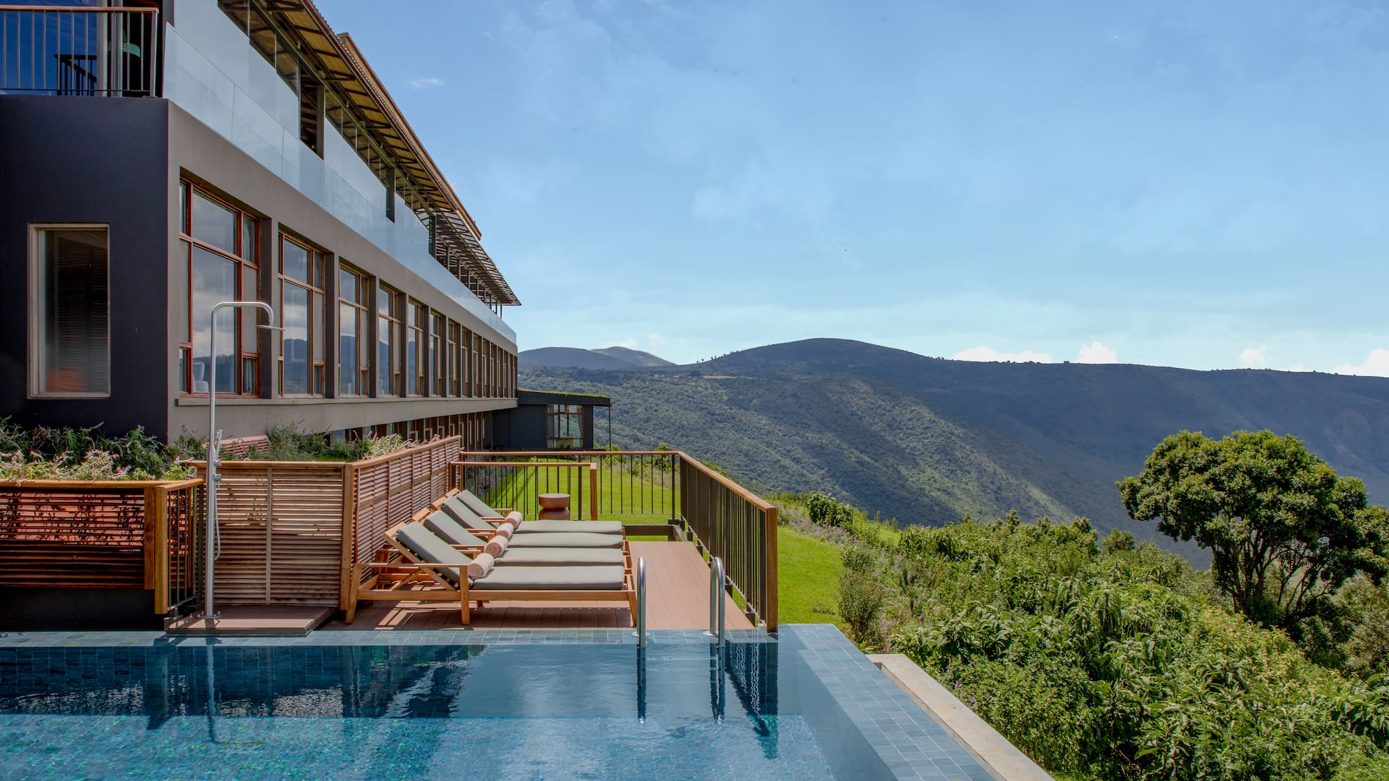 a pool with chairs and a building in the background