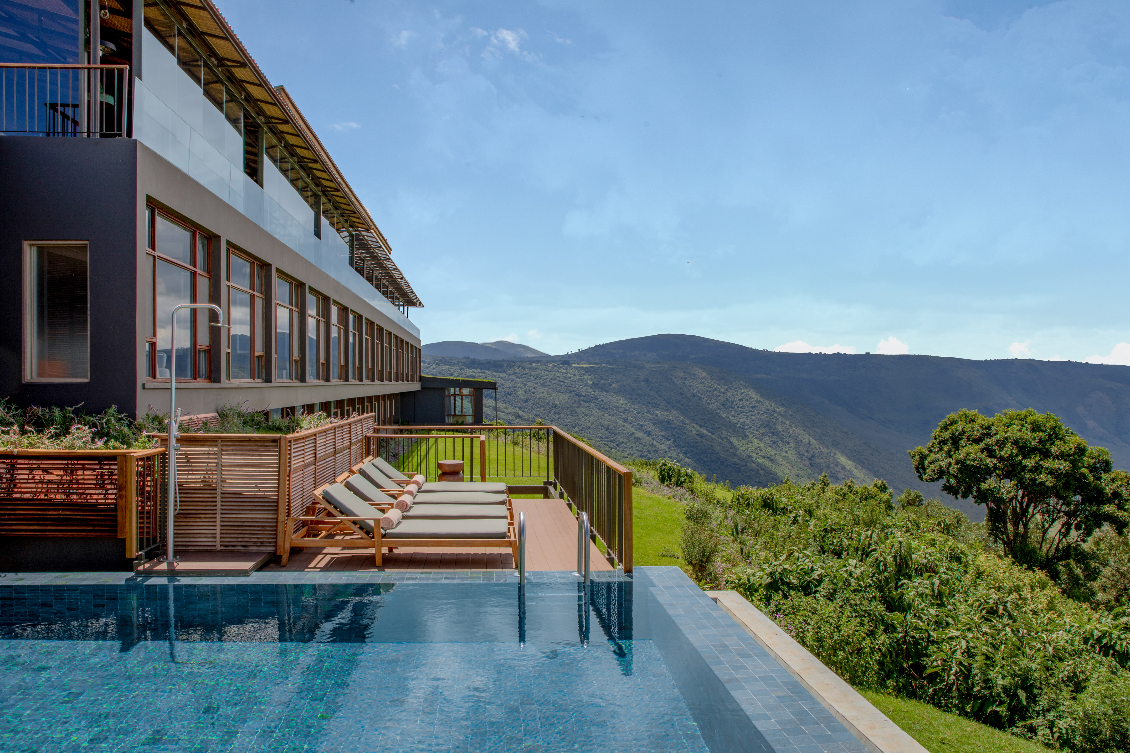 a pool with chairs and a building in the background