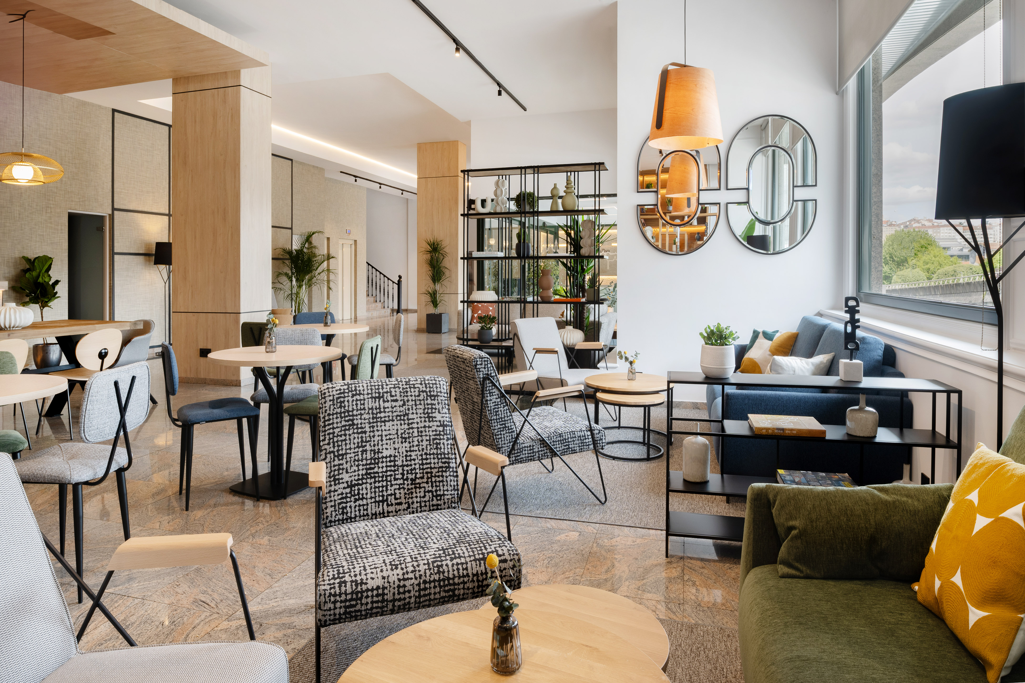 Lobby de hotel moderno con sillones, mesas y sofás; diseño interior luminoso.