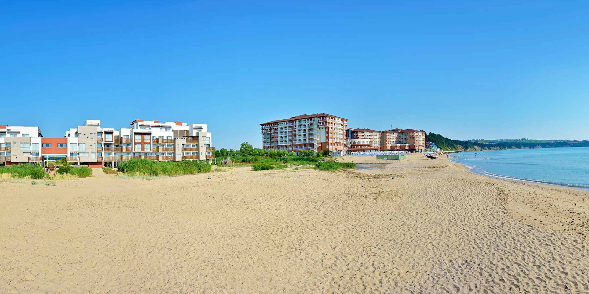 a beach with buildings and sand