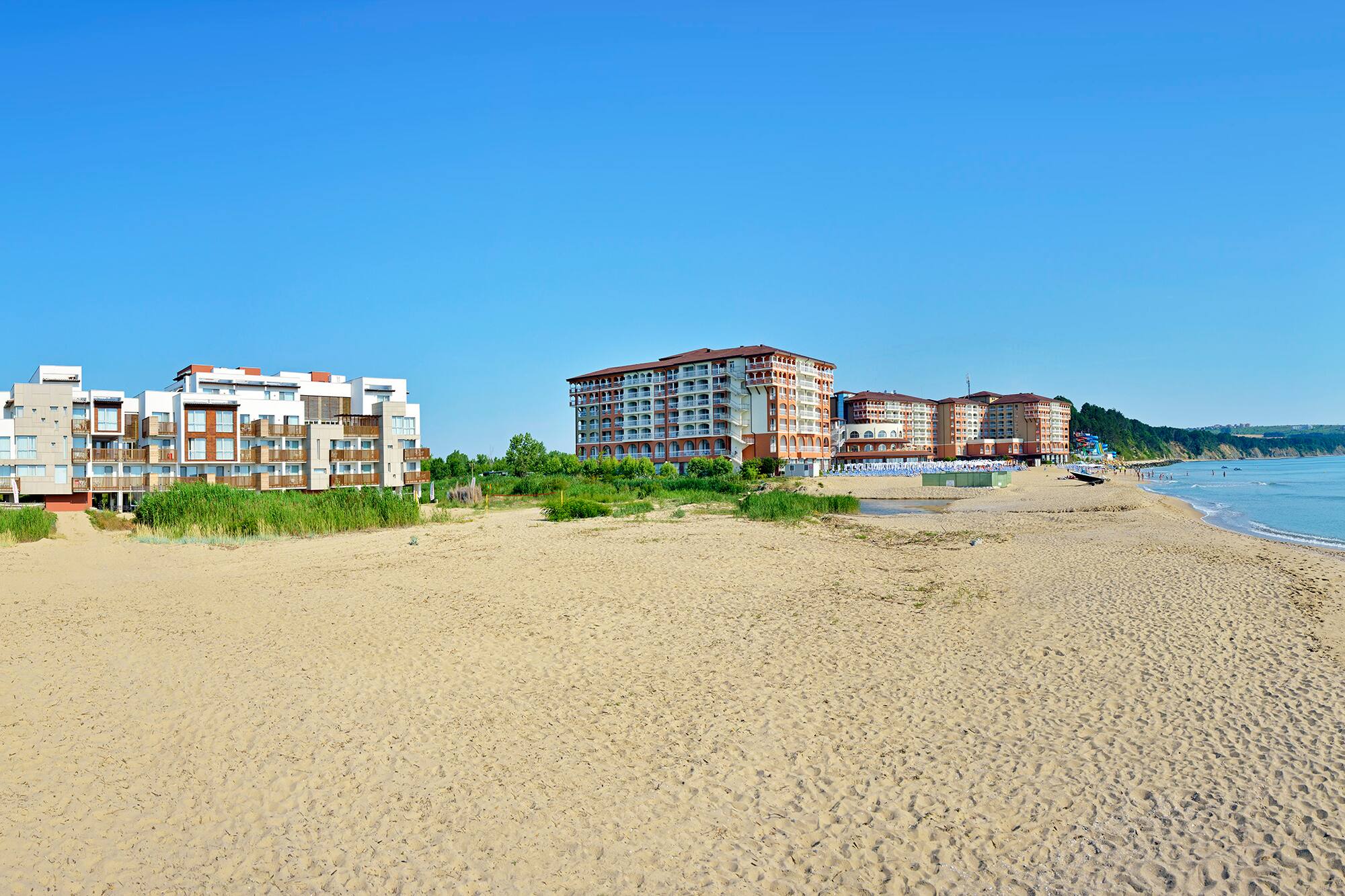 a beach with buildings and sand