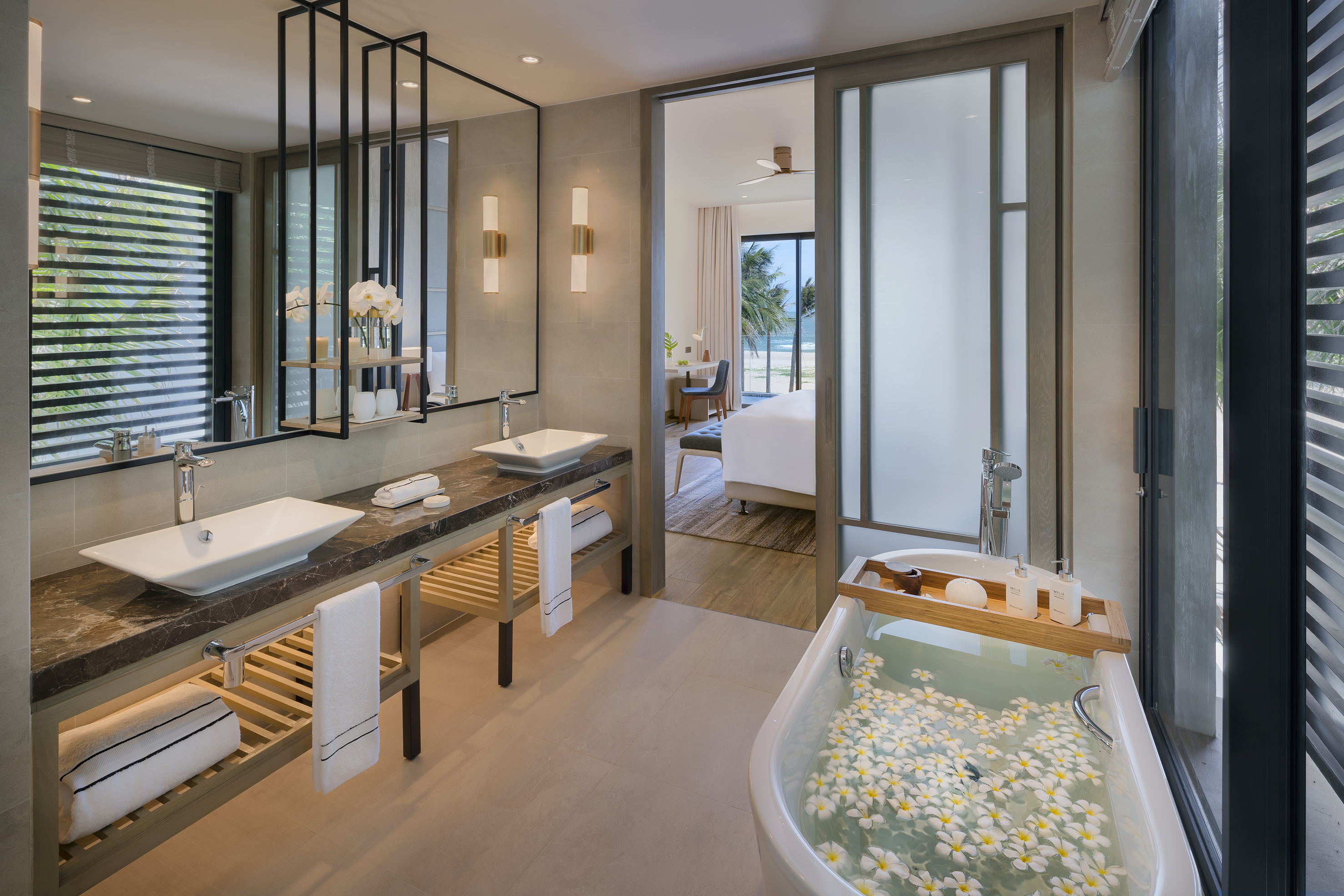 Modern bathroom, double vanity, flower bath, ocean view suite.