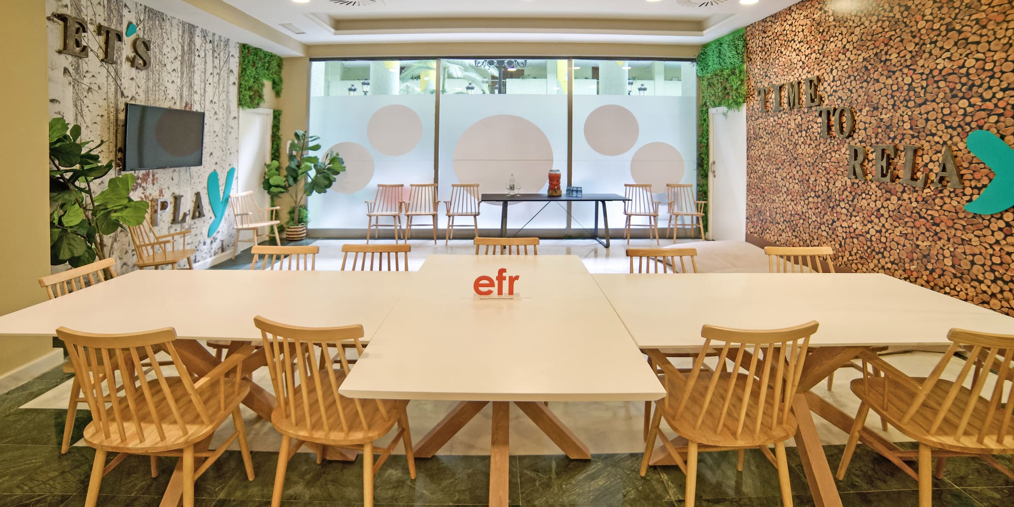 a room with white tables and wooden chairs