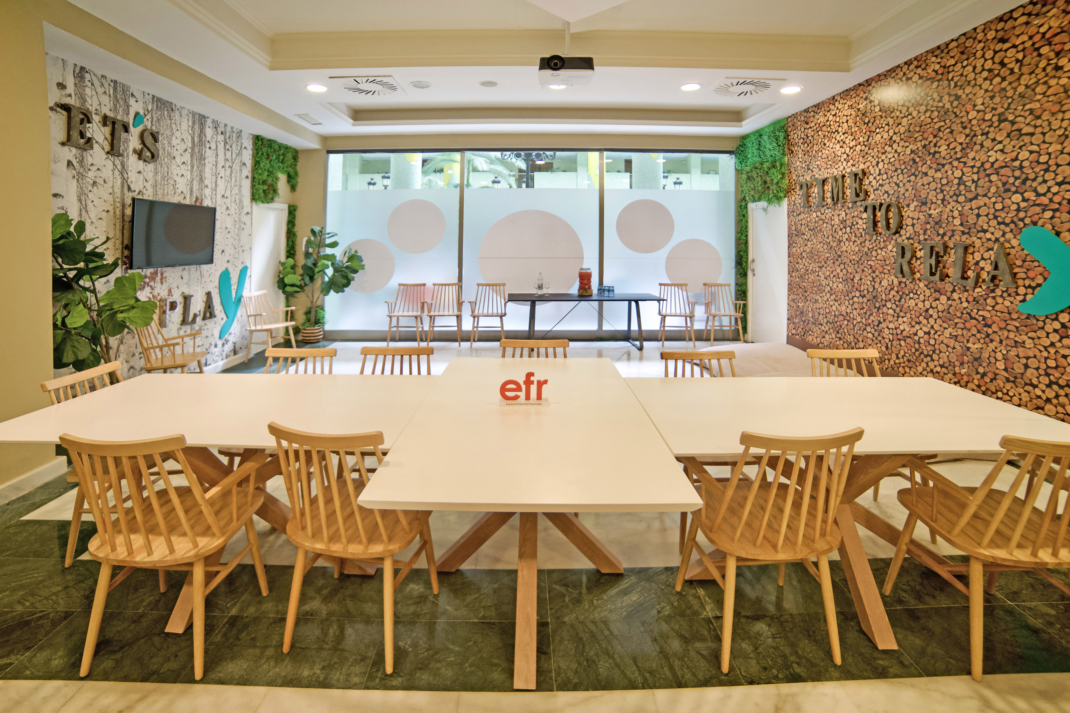 a room with white tables and wooden chairs