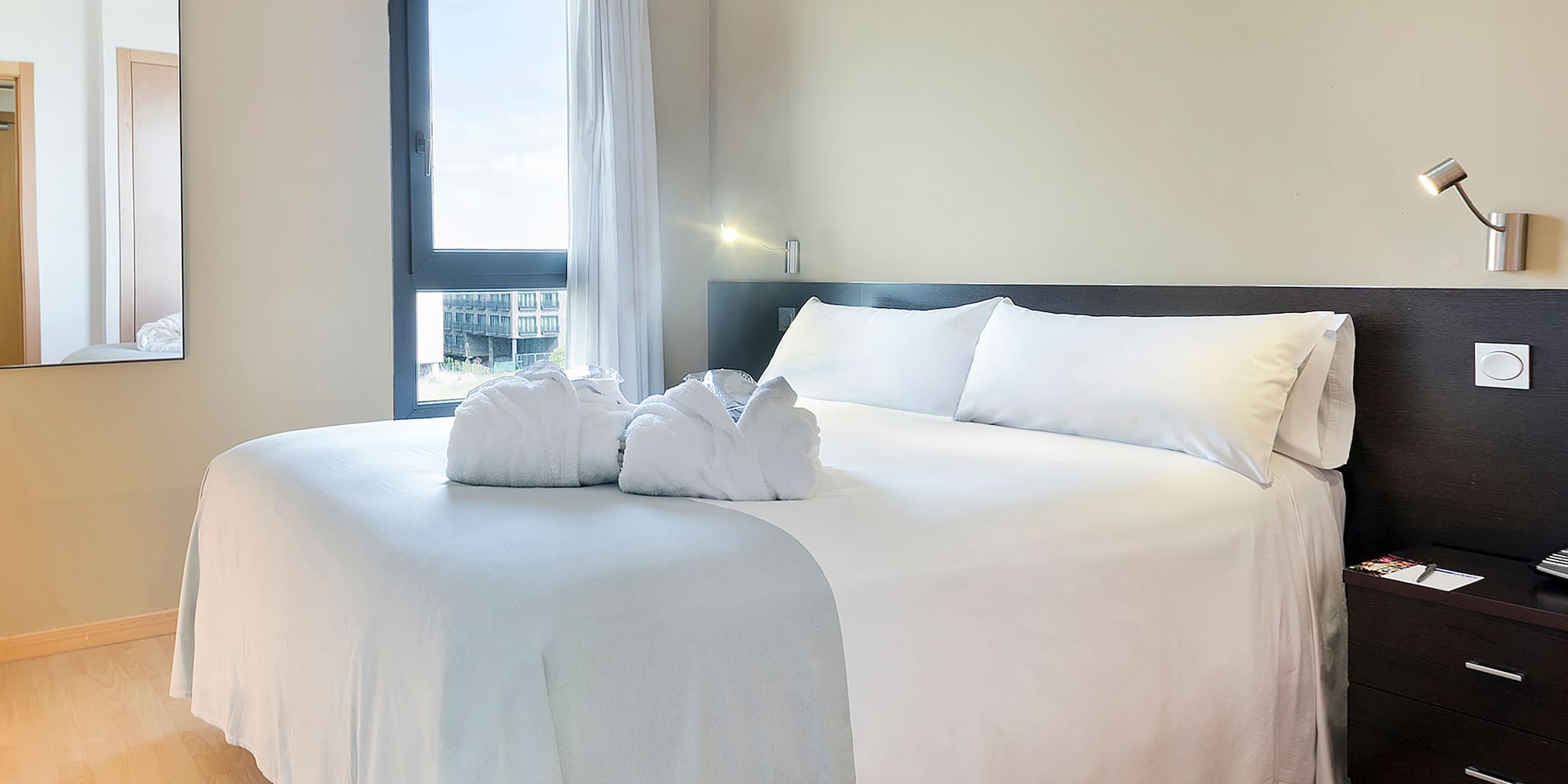 a bed with white sheets and towels on it