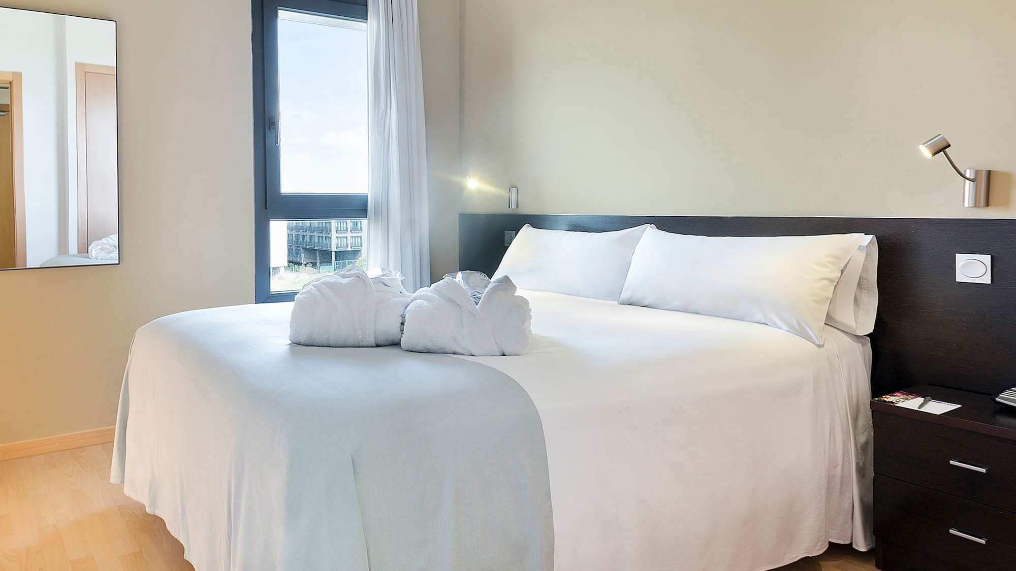 a bed with white sheets and towels on it