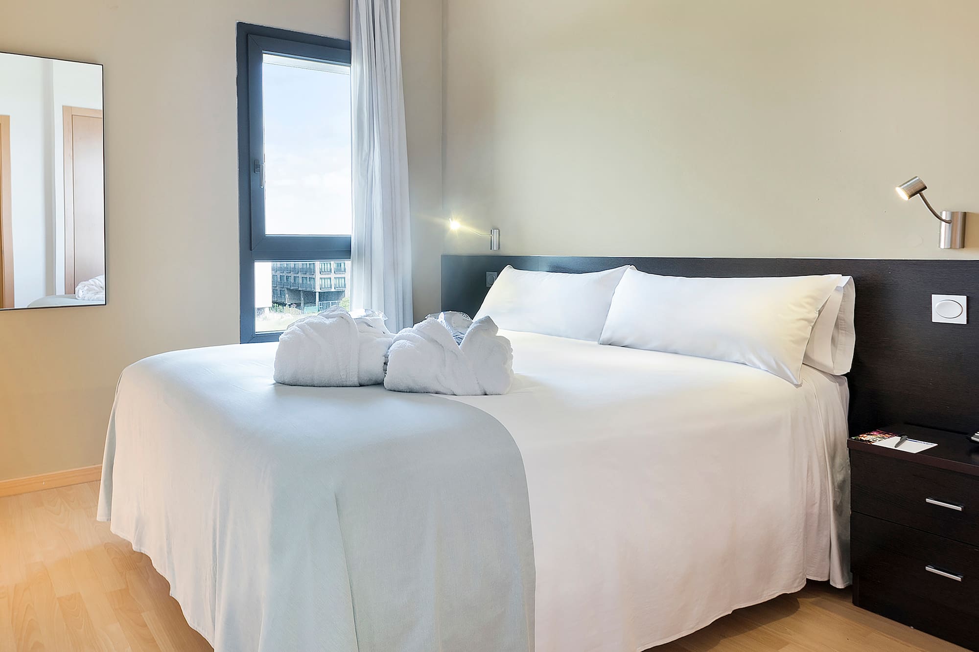 a bed with white sheets and towels on it