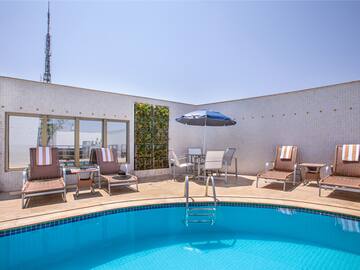 a pool with chairs and umbrella