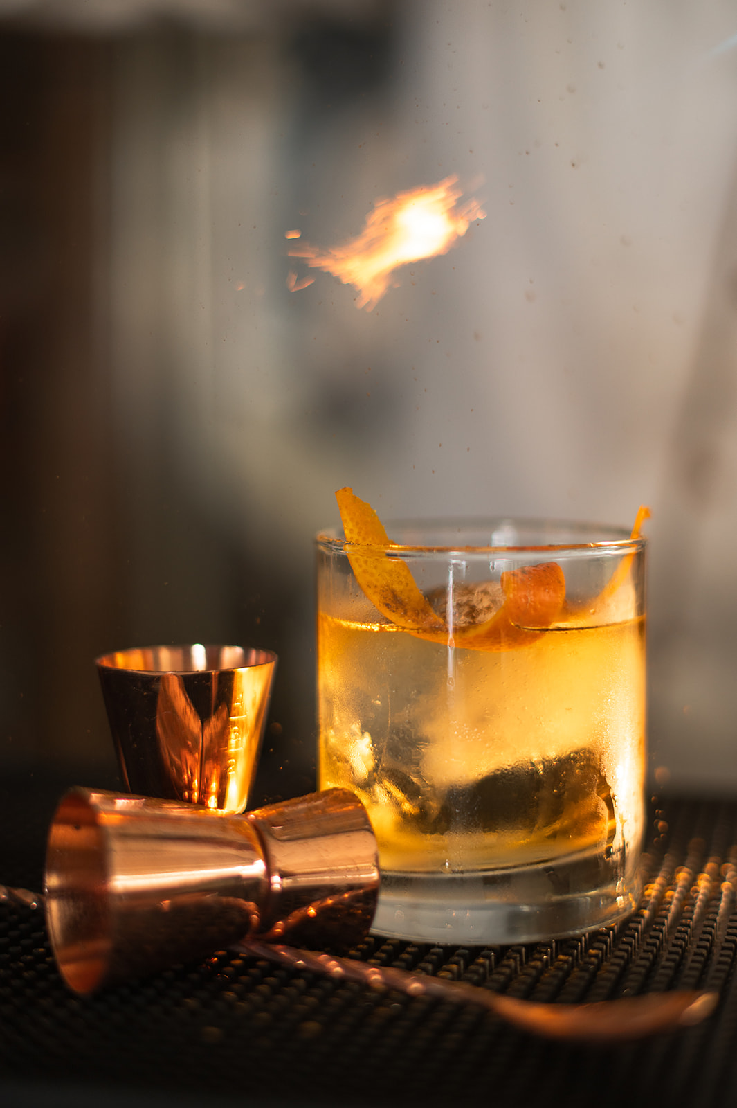 a glass with a drink and a fire above it
