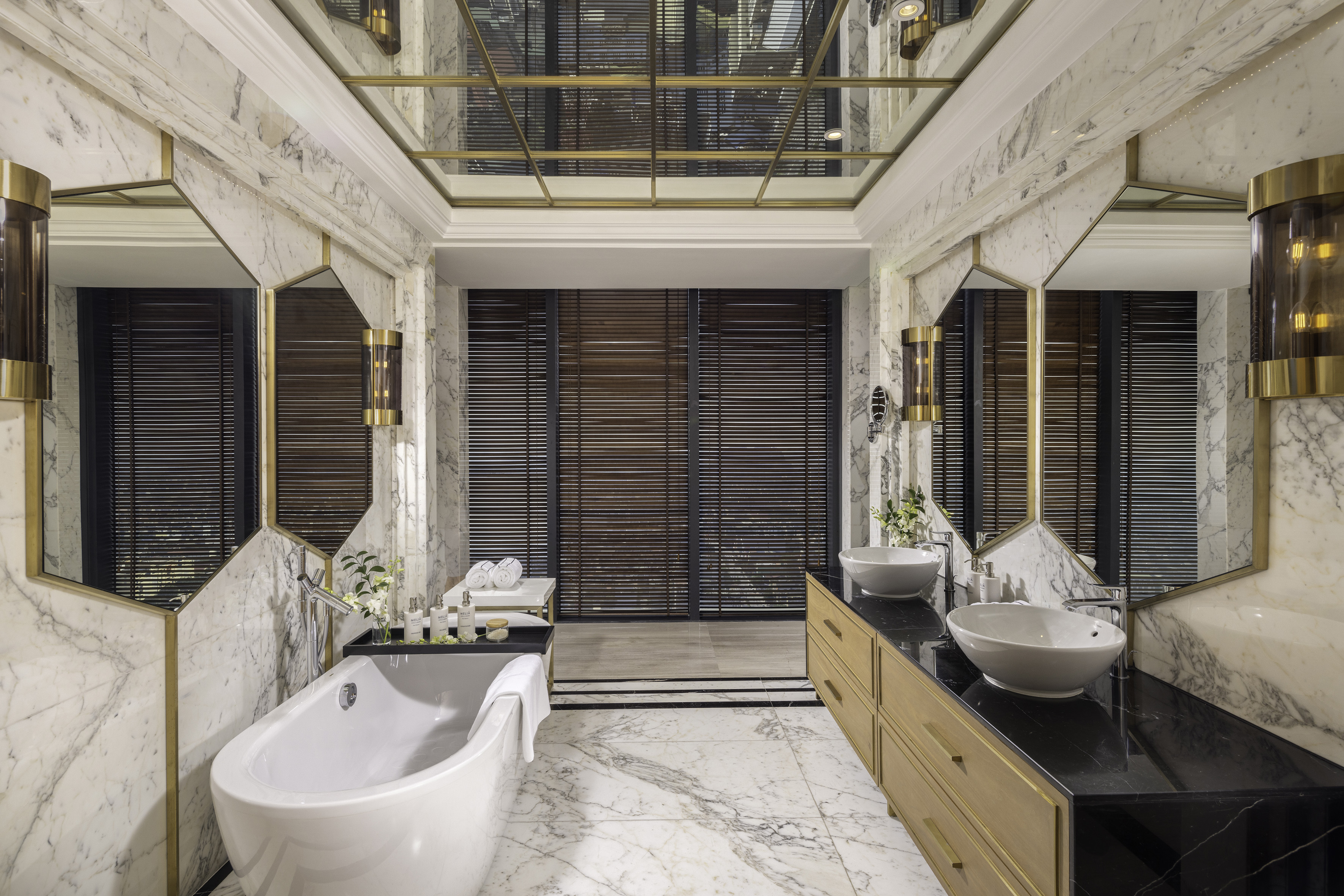 Luxurious marble bathroom with freestanding tub, double vanity, and brass accents.