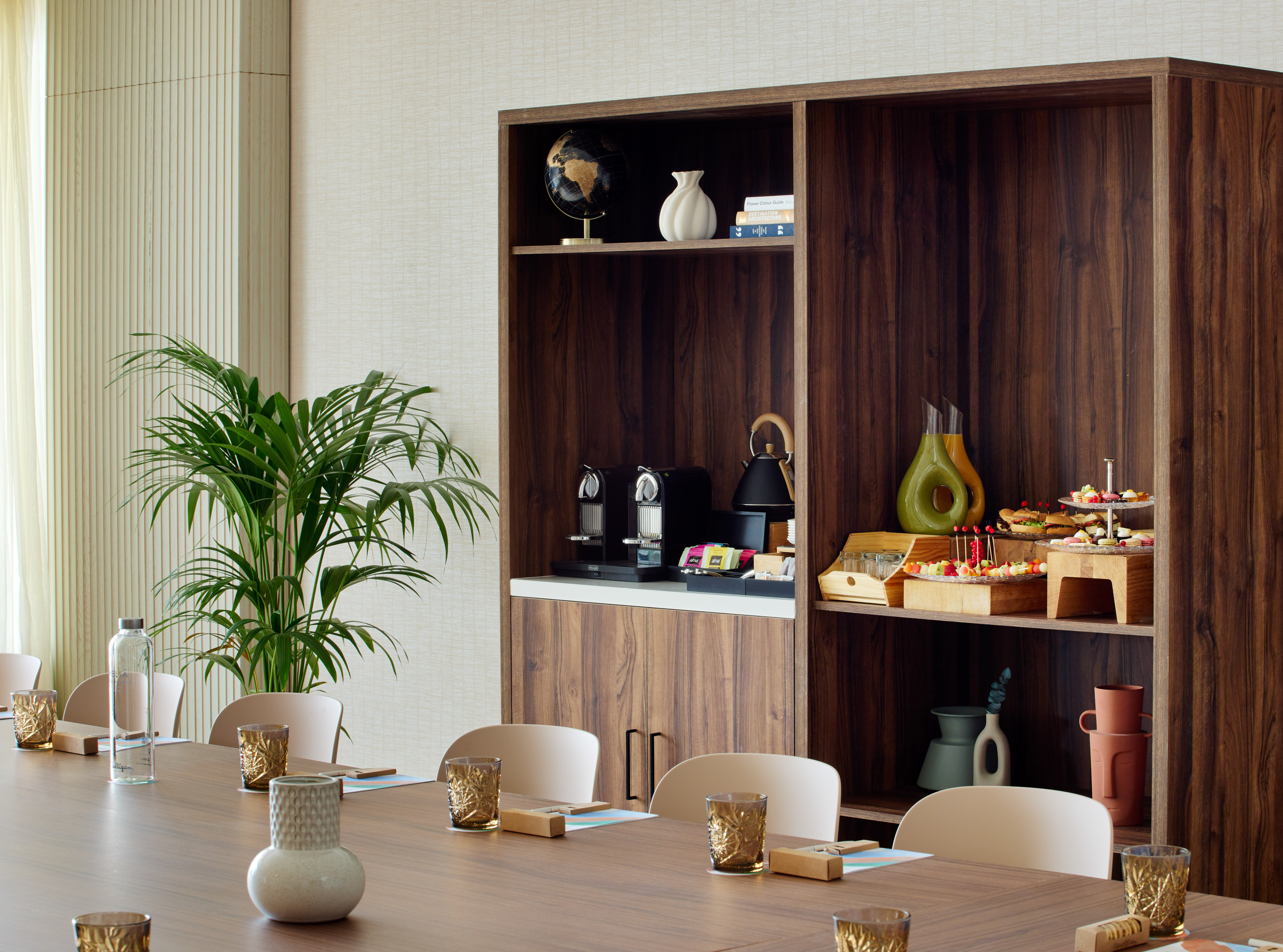 Contemporary meeting room with built-in refreshment station and long table.