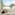Woman in bed, family on balcony overlooking beach and palm trees.