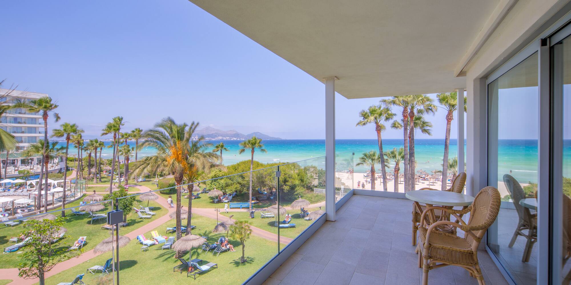 a balcony with a view of the beach and palm trees