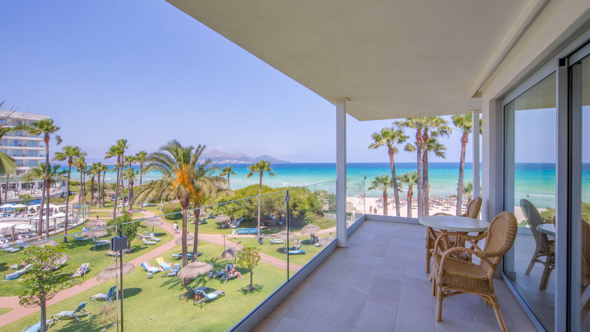 a balcony with a view of the beach and palm trees