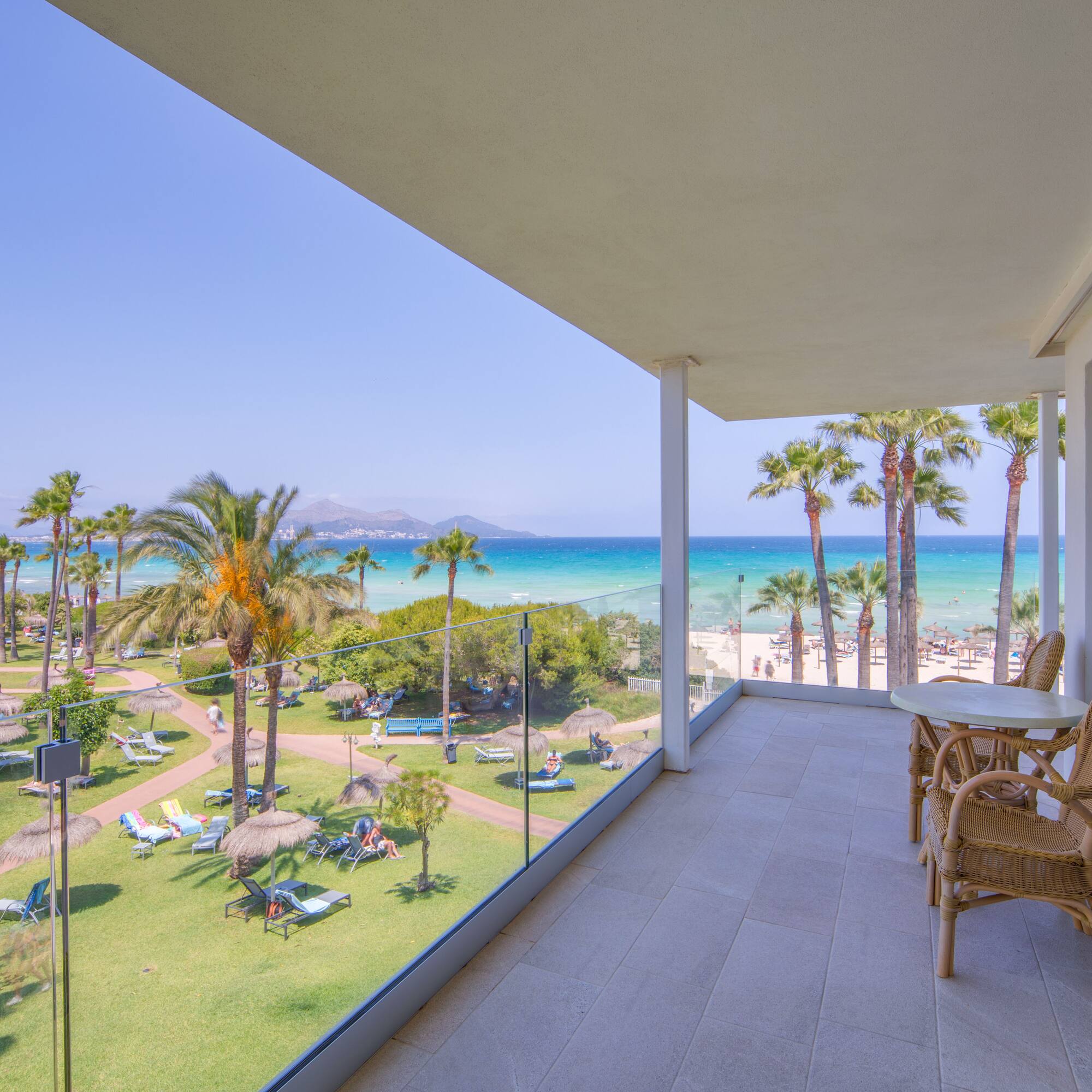 a balcony with a view of the beach and palm trees