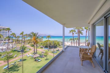 a balcony with a view of the beach and palm trees