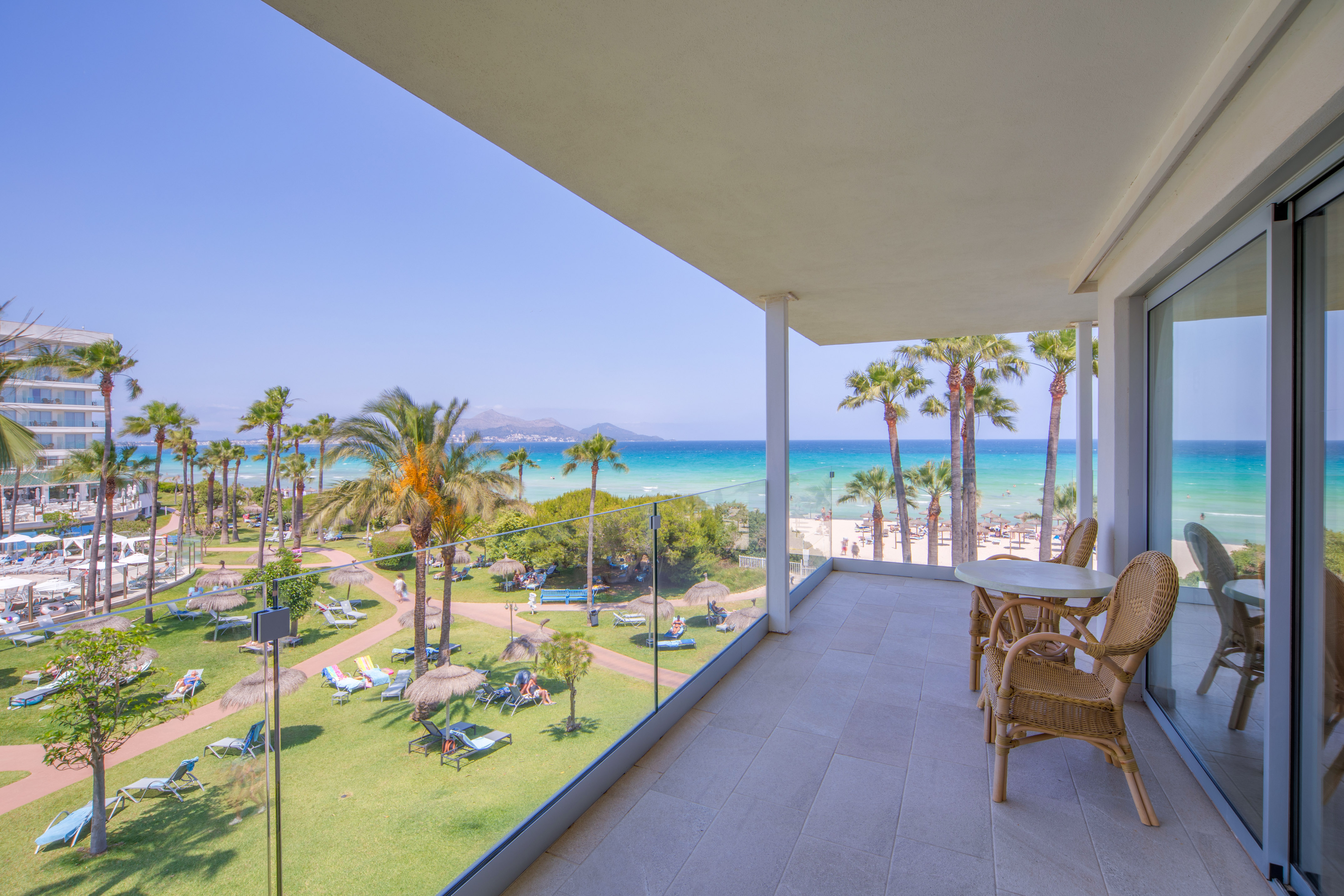 a balcony with a view of the beach and palm trees
