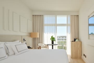 a bedroom with a bed and a table and chairs