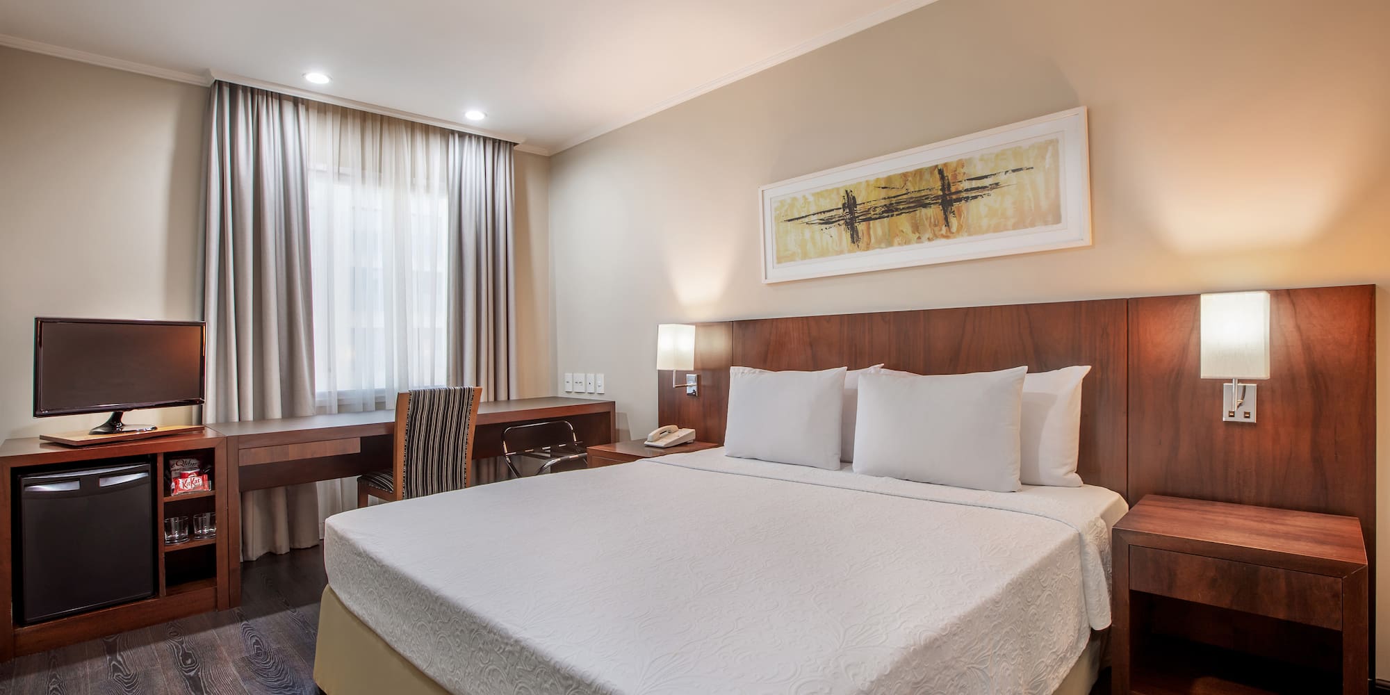 a bed with a desk and chair in a hotel room