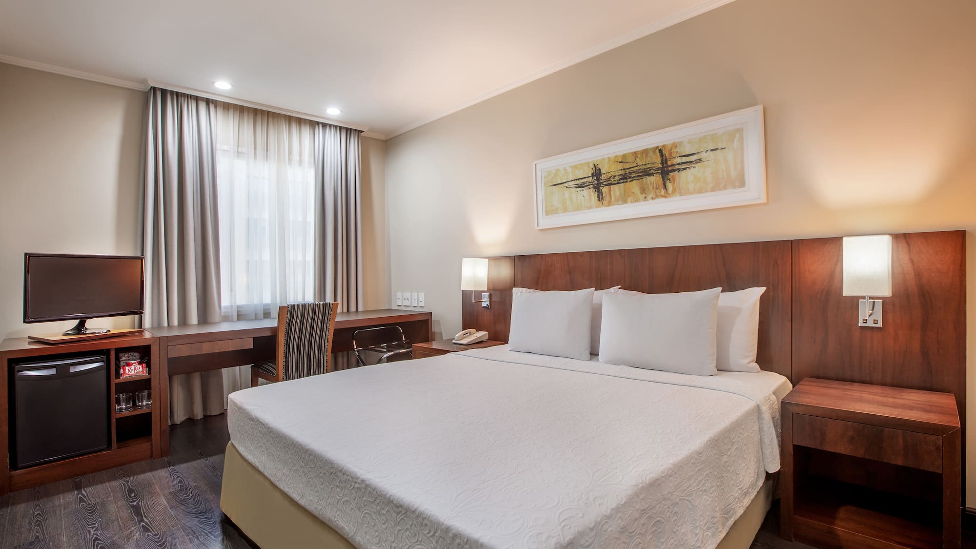 a bed with a desk and chair in a hotel room