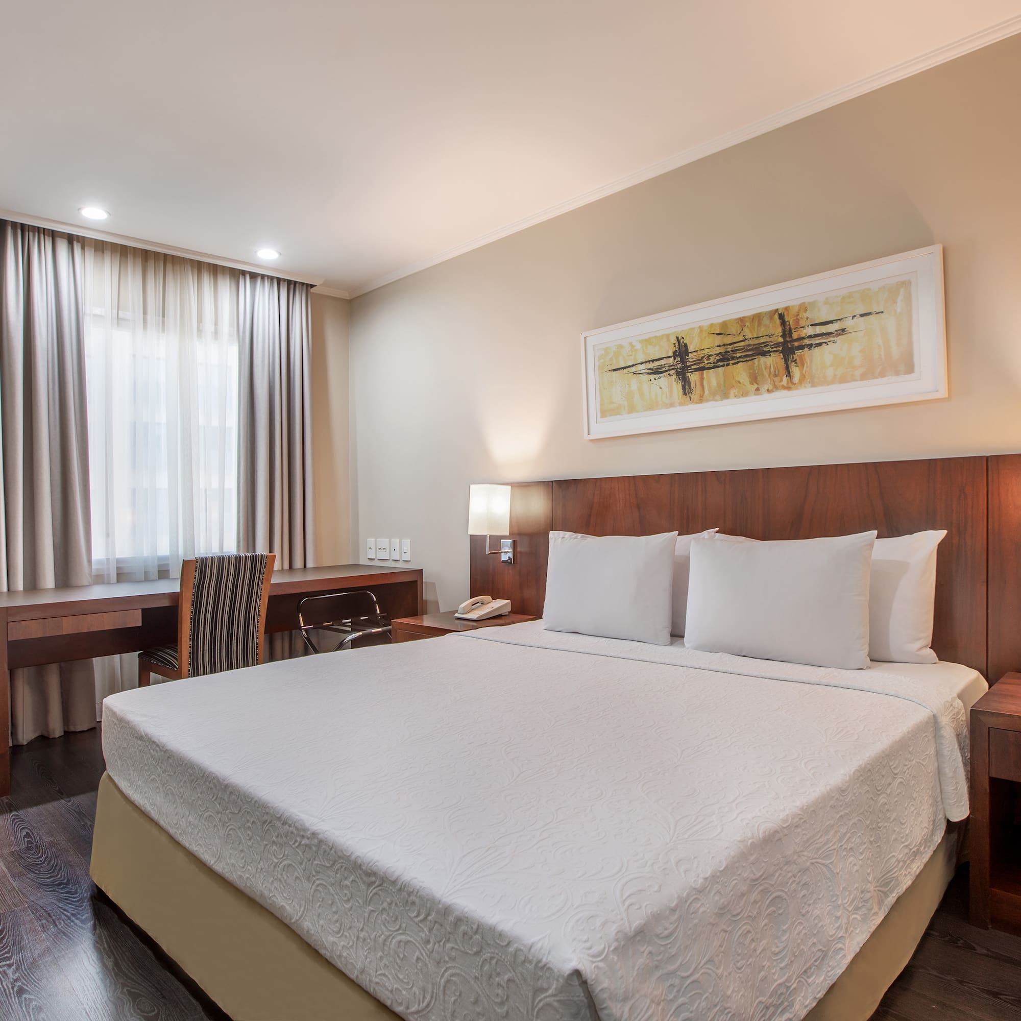 a bed with a desk and chair in a hotel room