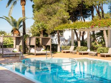 a pool with lounge chairs and trees