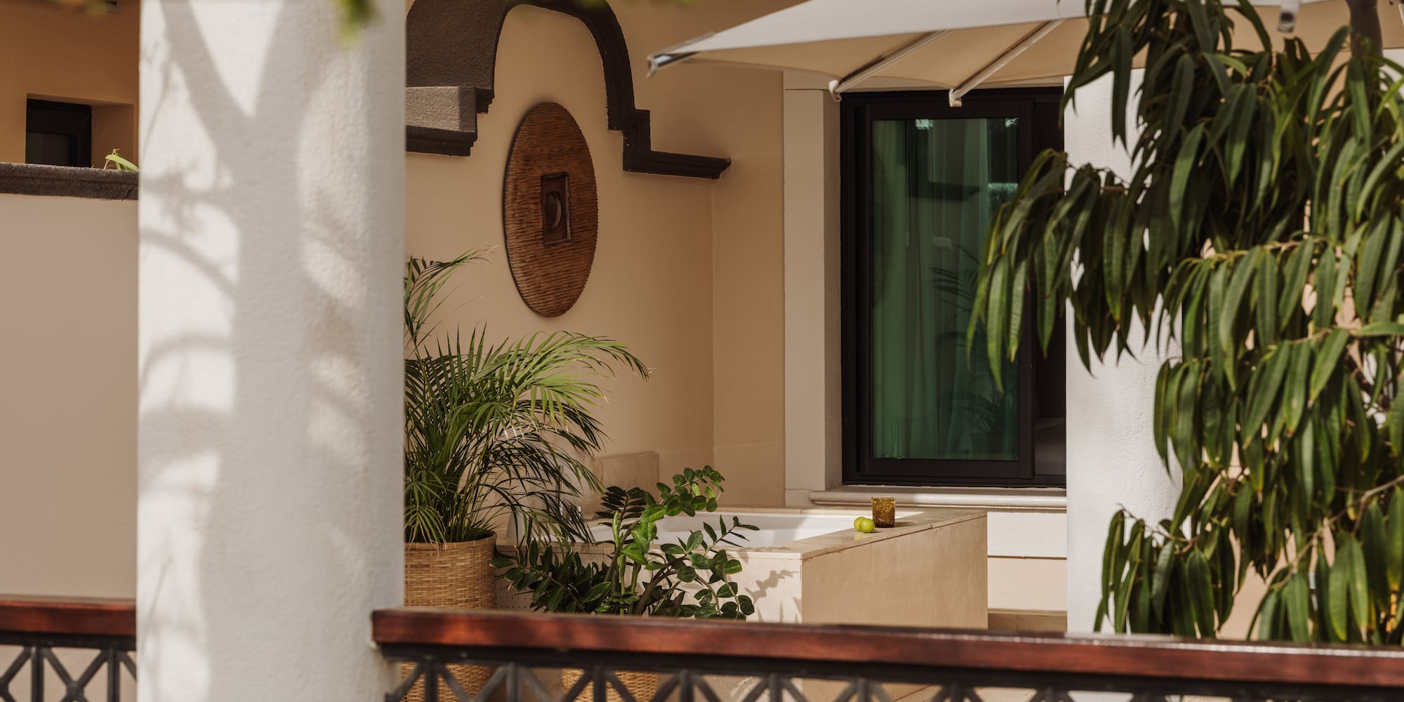 a white building with a white umbrella and plants