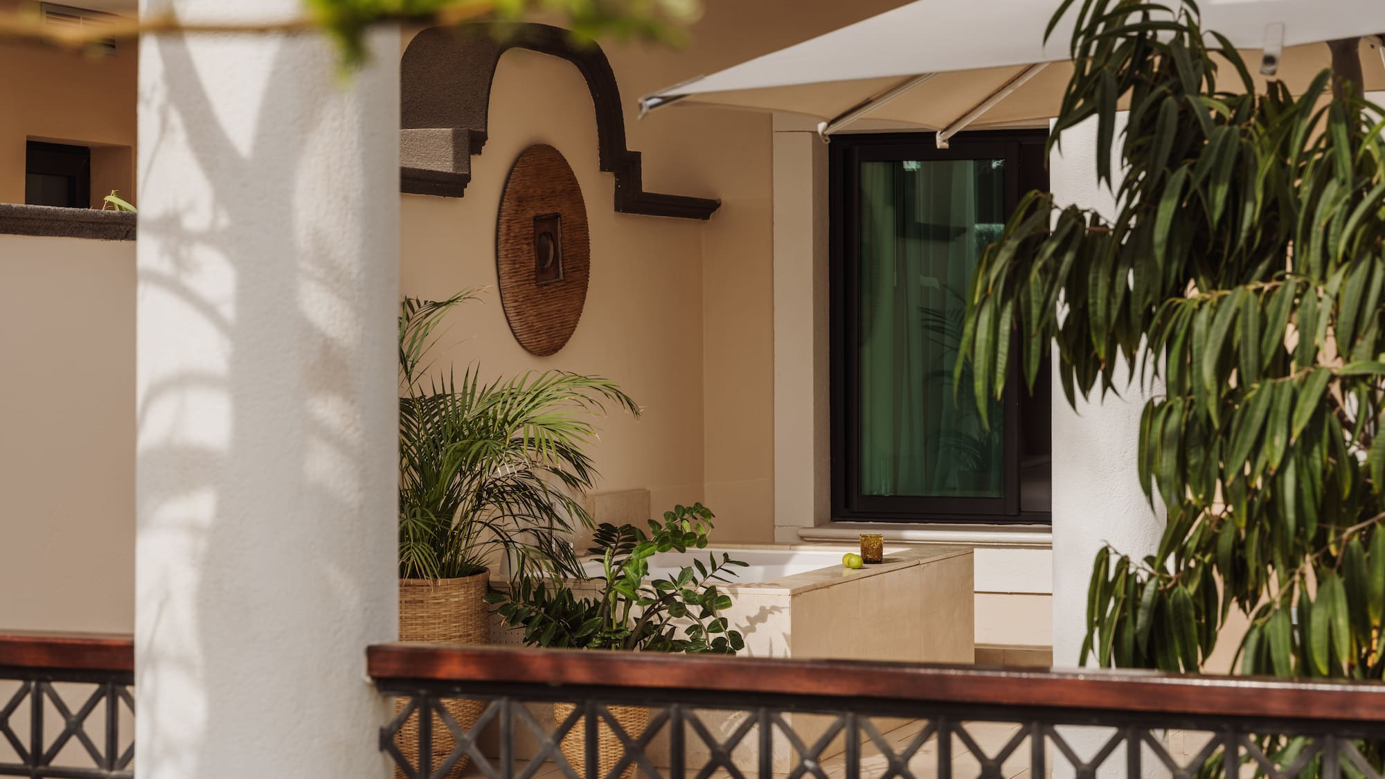 a white building with a white umbrella and plants
