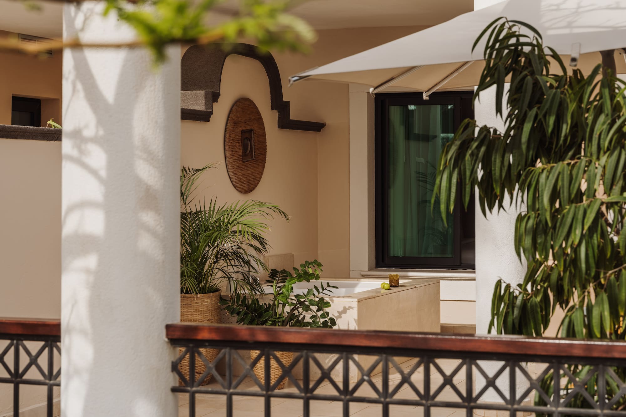 a white building with a white umbrella and plants