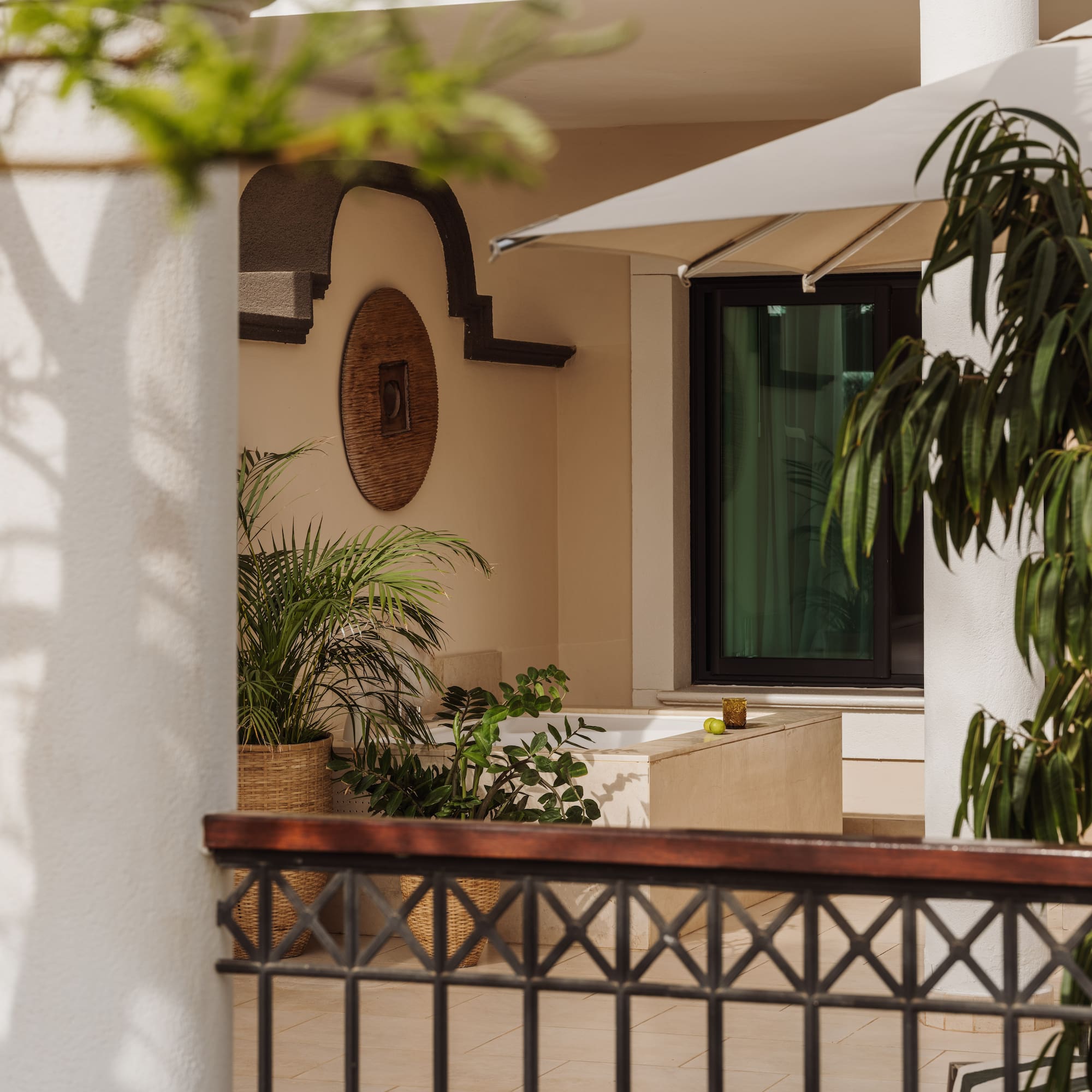 a white building with a white umbrella and plants