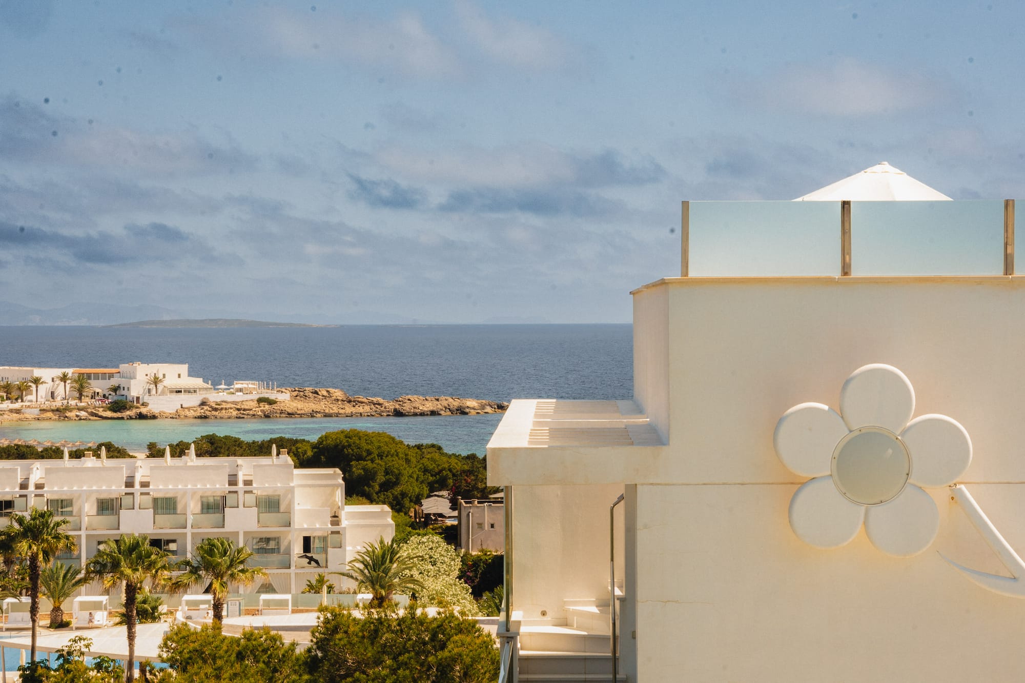 a white building with a flower on the side