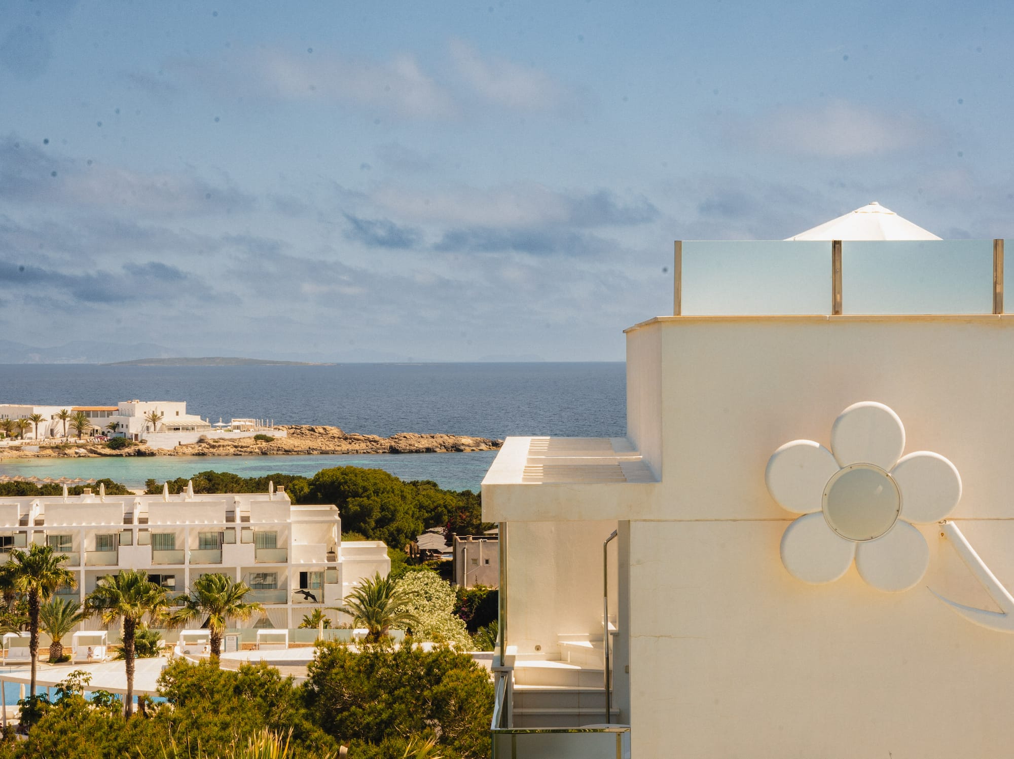 a white building with a flower on the side