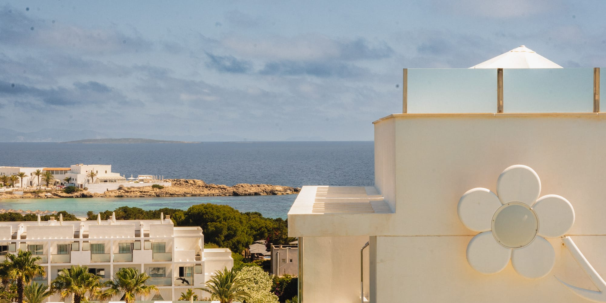 a white building with a flower on the side