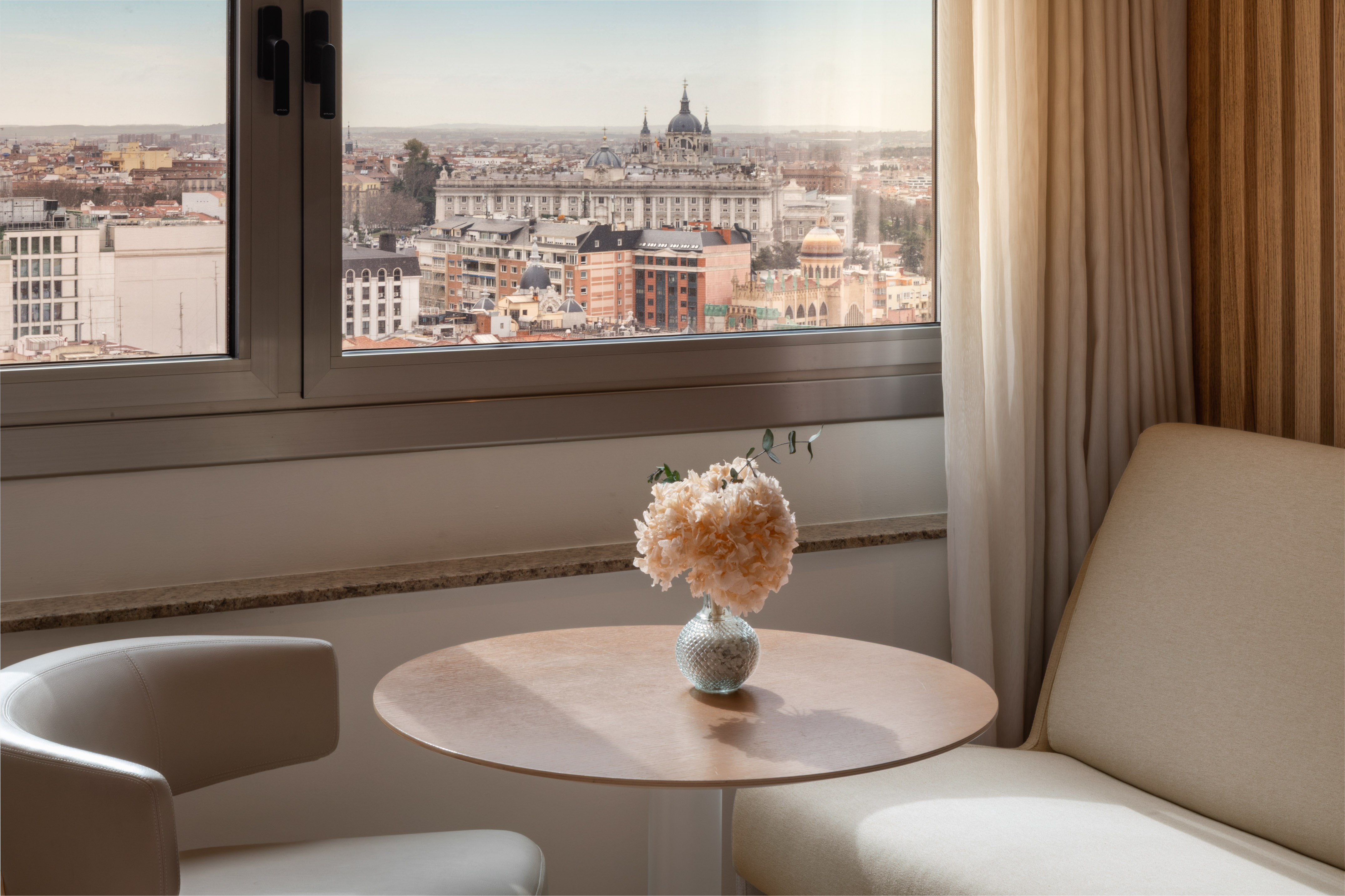Madrid city view from window, Almudena Cathedral, table with flowers.