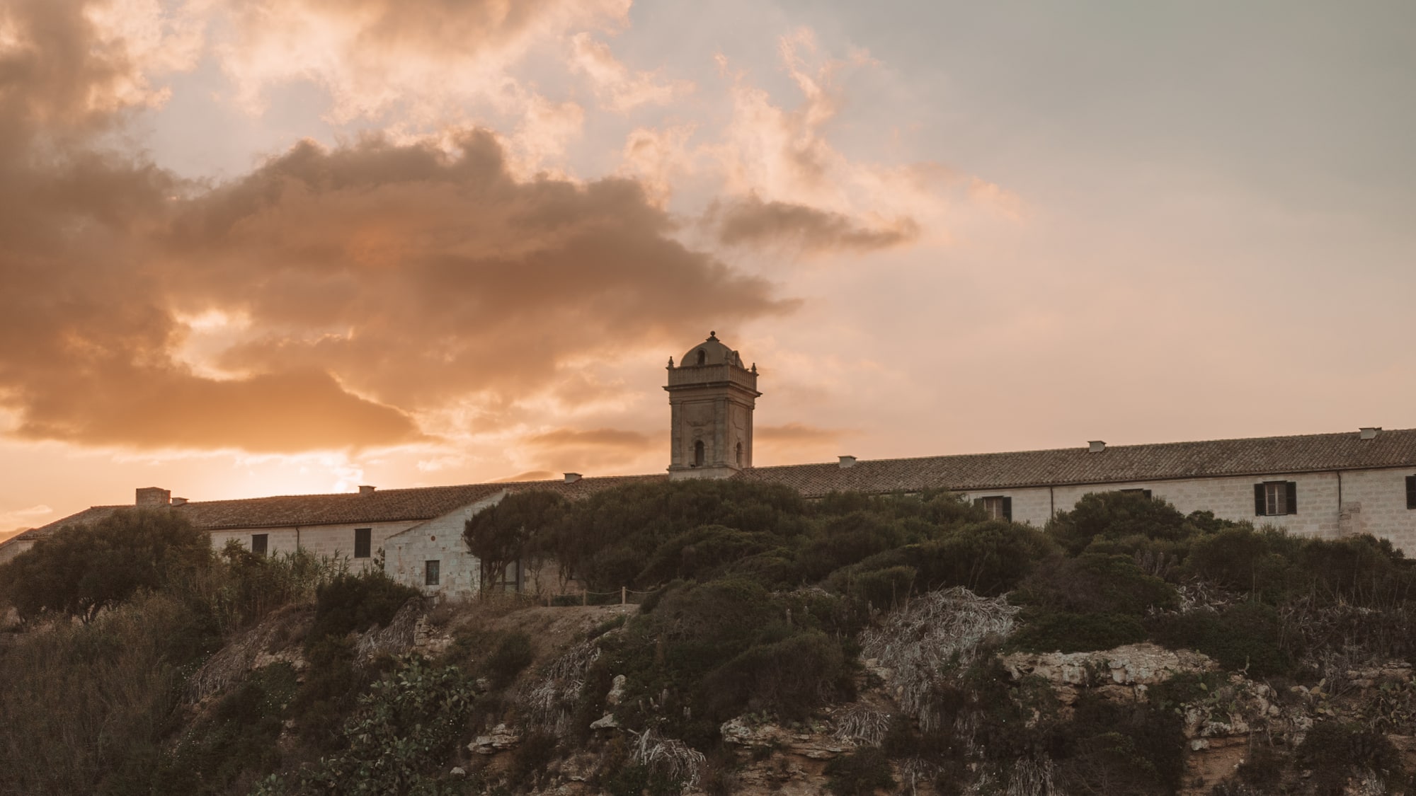 a building with a tower on top of a cliff