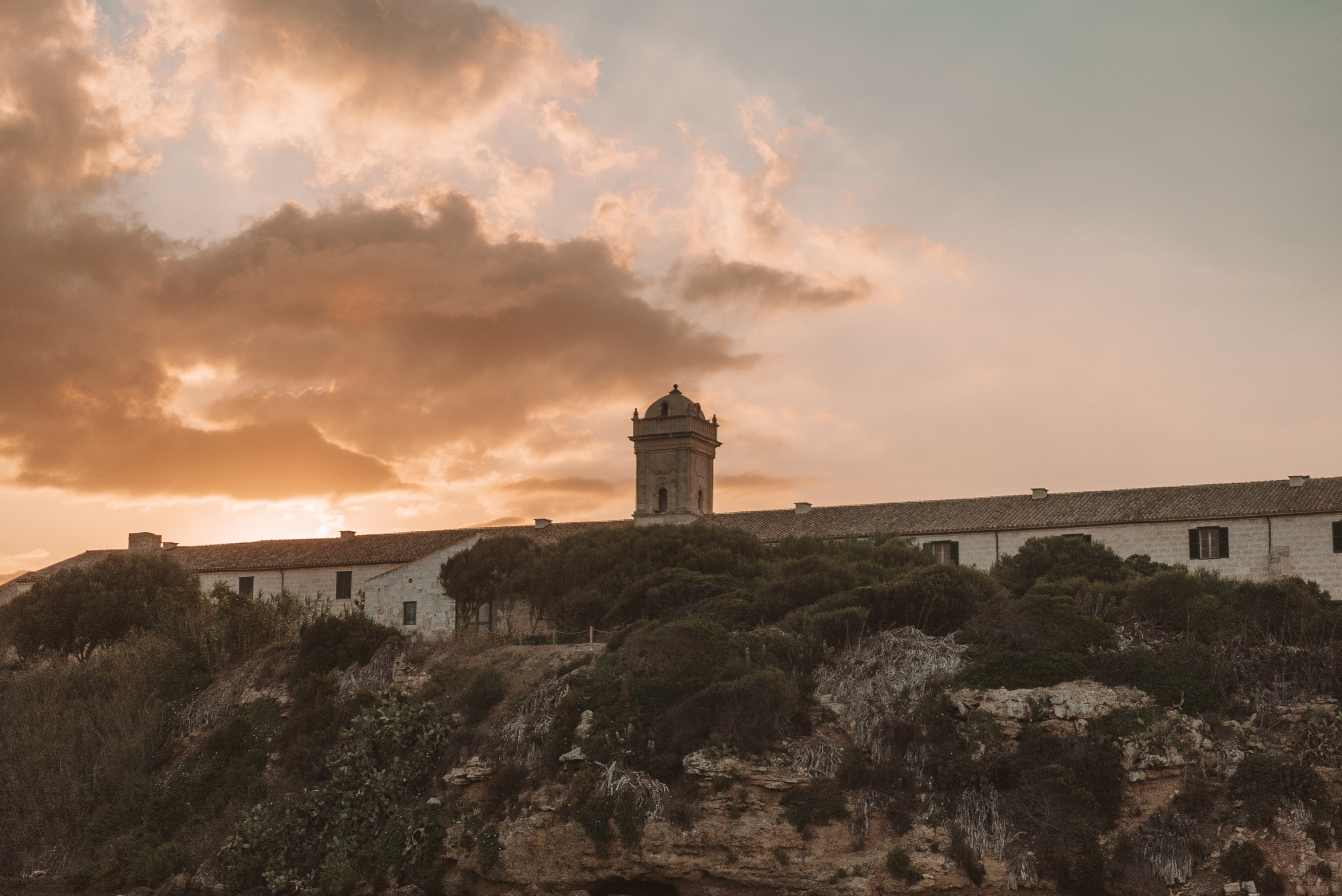 a building with a tower on top of a cliff