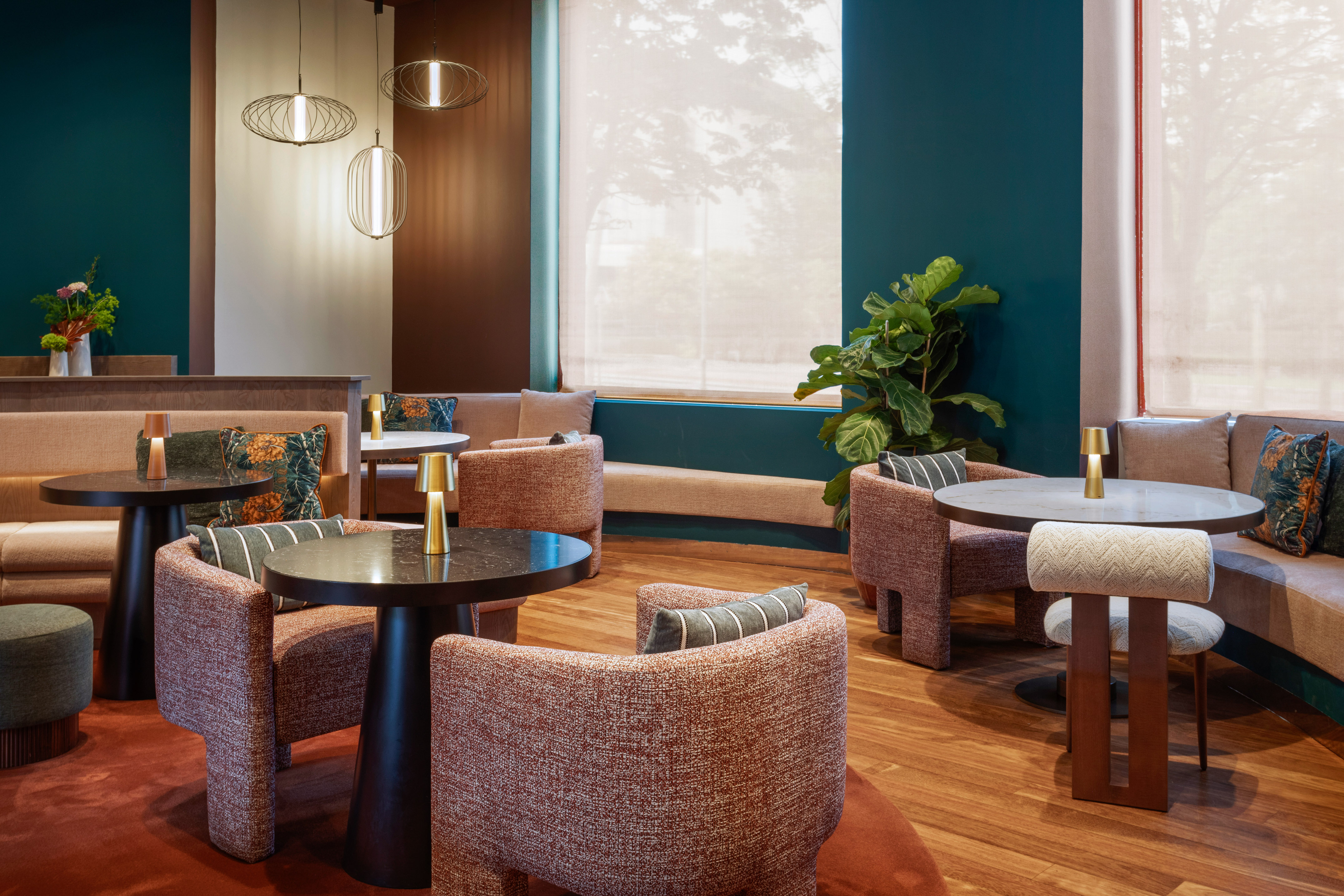 Modern lounge with plush seating, warm lighting, and dark teal accents.