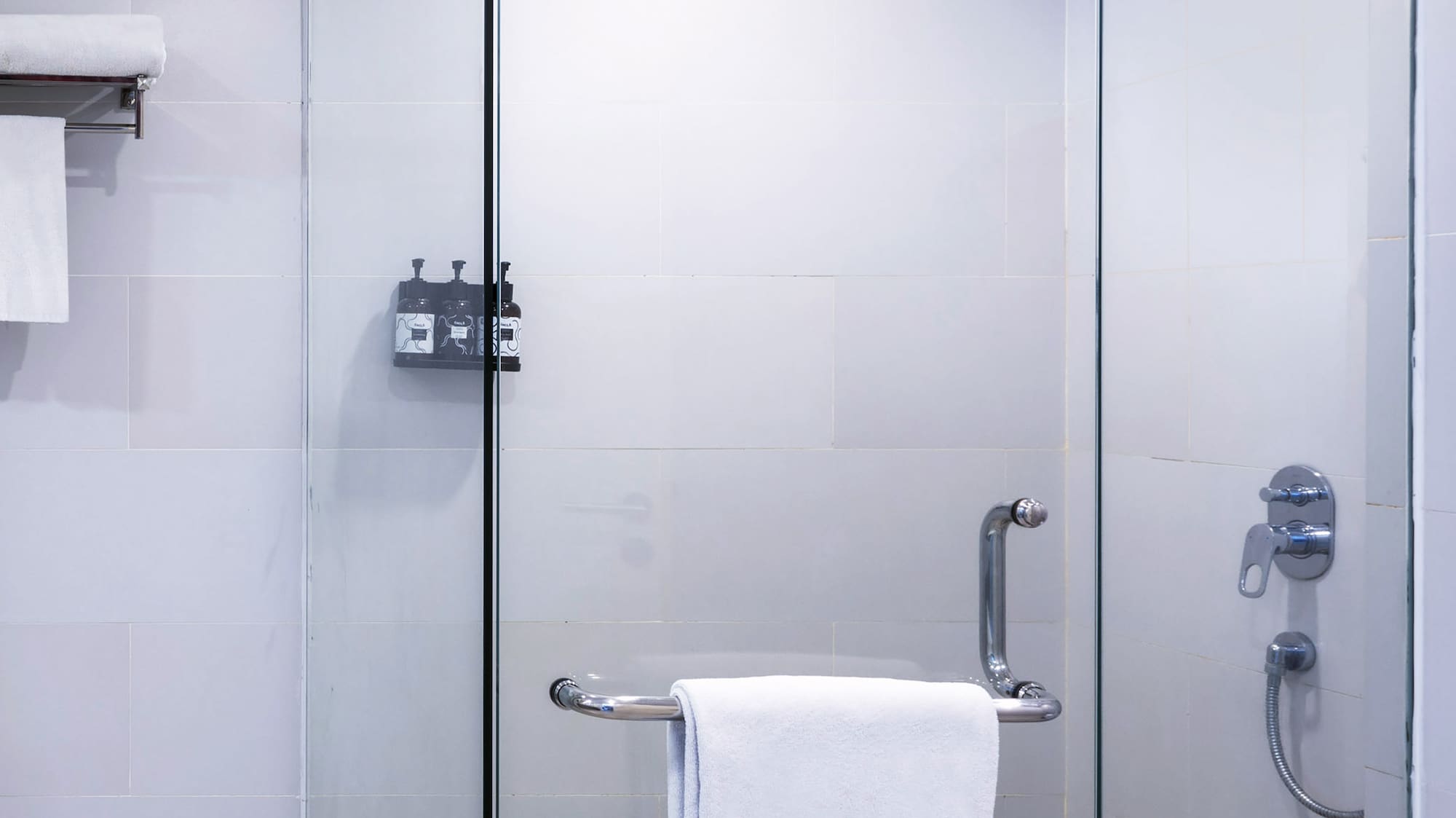 a glass shower with a towel on a bar