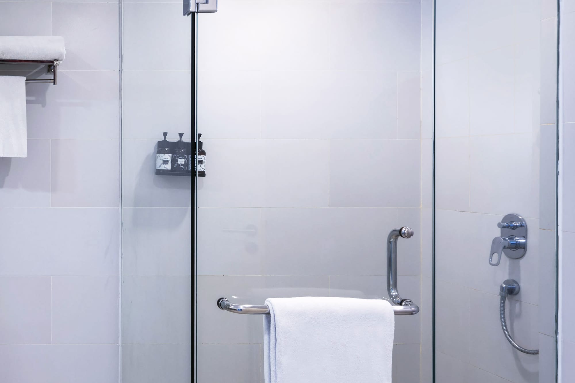 a glass shower with a towel on a bar