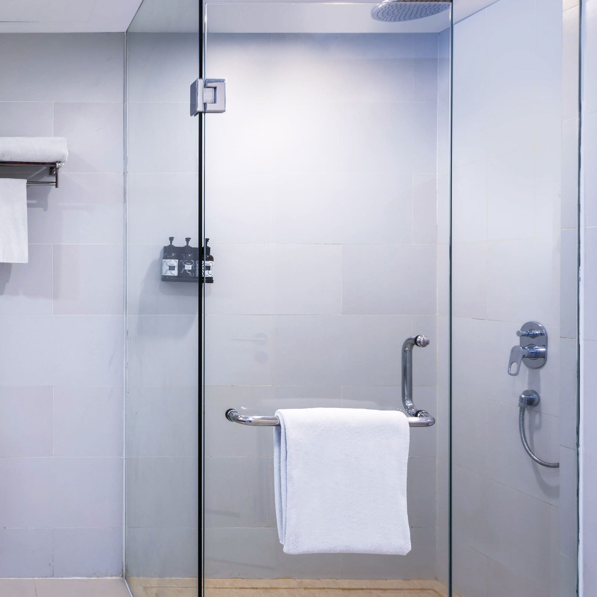 a glass shower with a towel on a bar