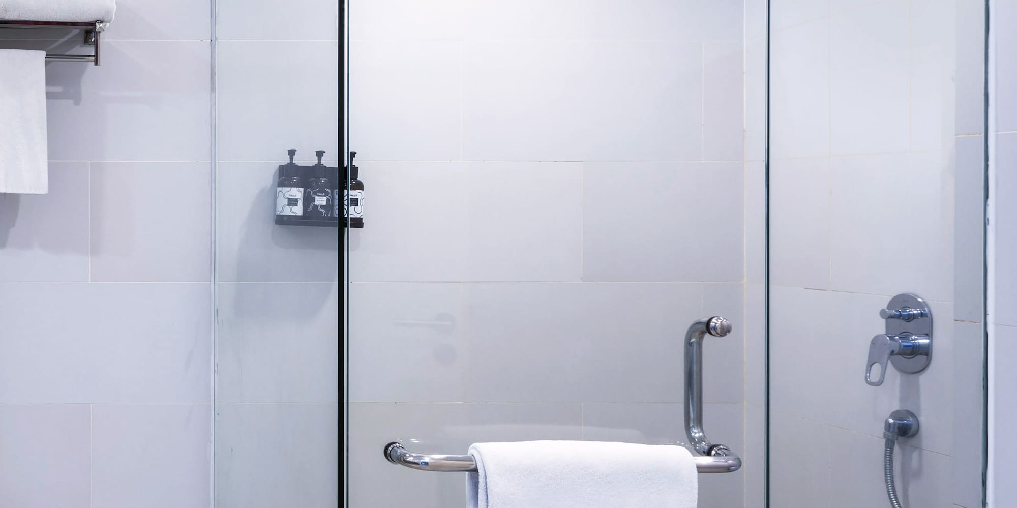 a glass shower with a towel on a bar