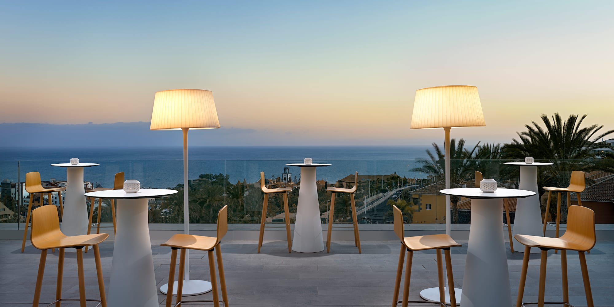 a group of tables and chairs with a view of the ocean